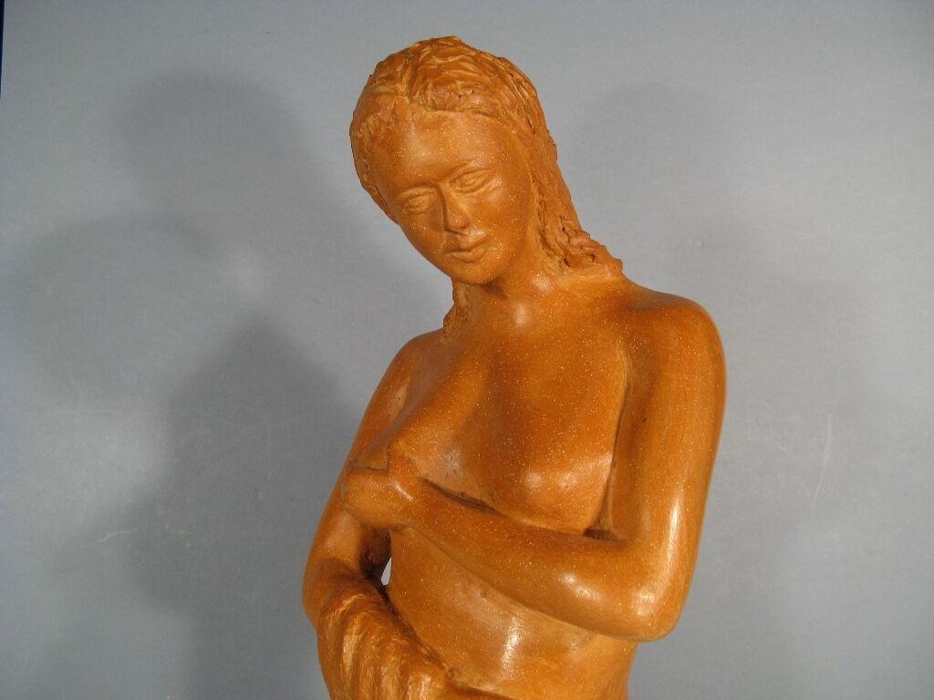 Esta sensual escultura de terracota representa a una joven saliendo del baño. Creada a mediados del siglo XX, la pieza desprende una belleza y una gracia intemporales. El artista permanece en el anonimato.

Características:

Material: