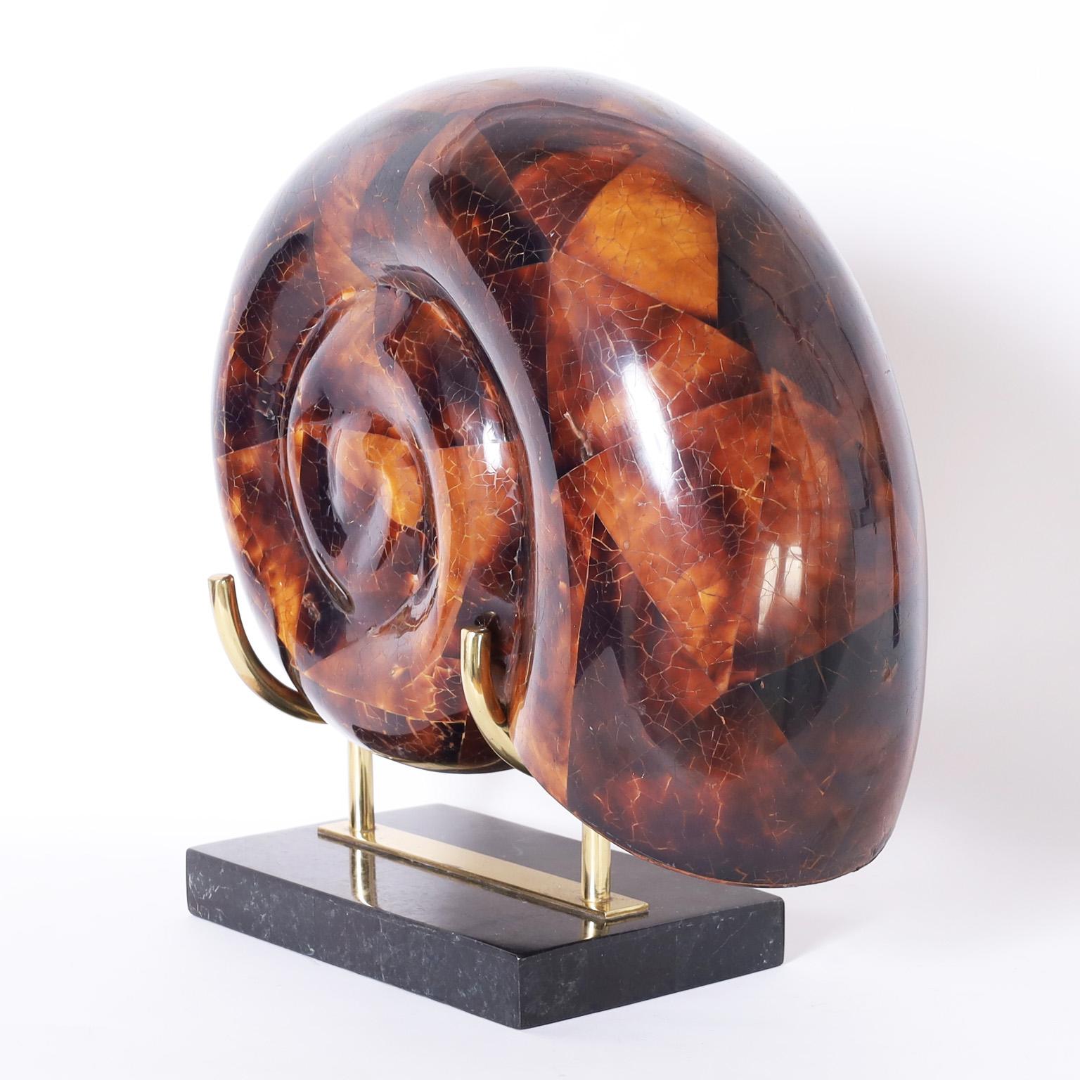 Eye catching vintage nautilus sculpture crafted in penshell and presented on a brass and stone stand by Maitland-Smith.