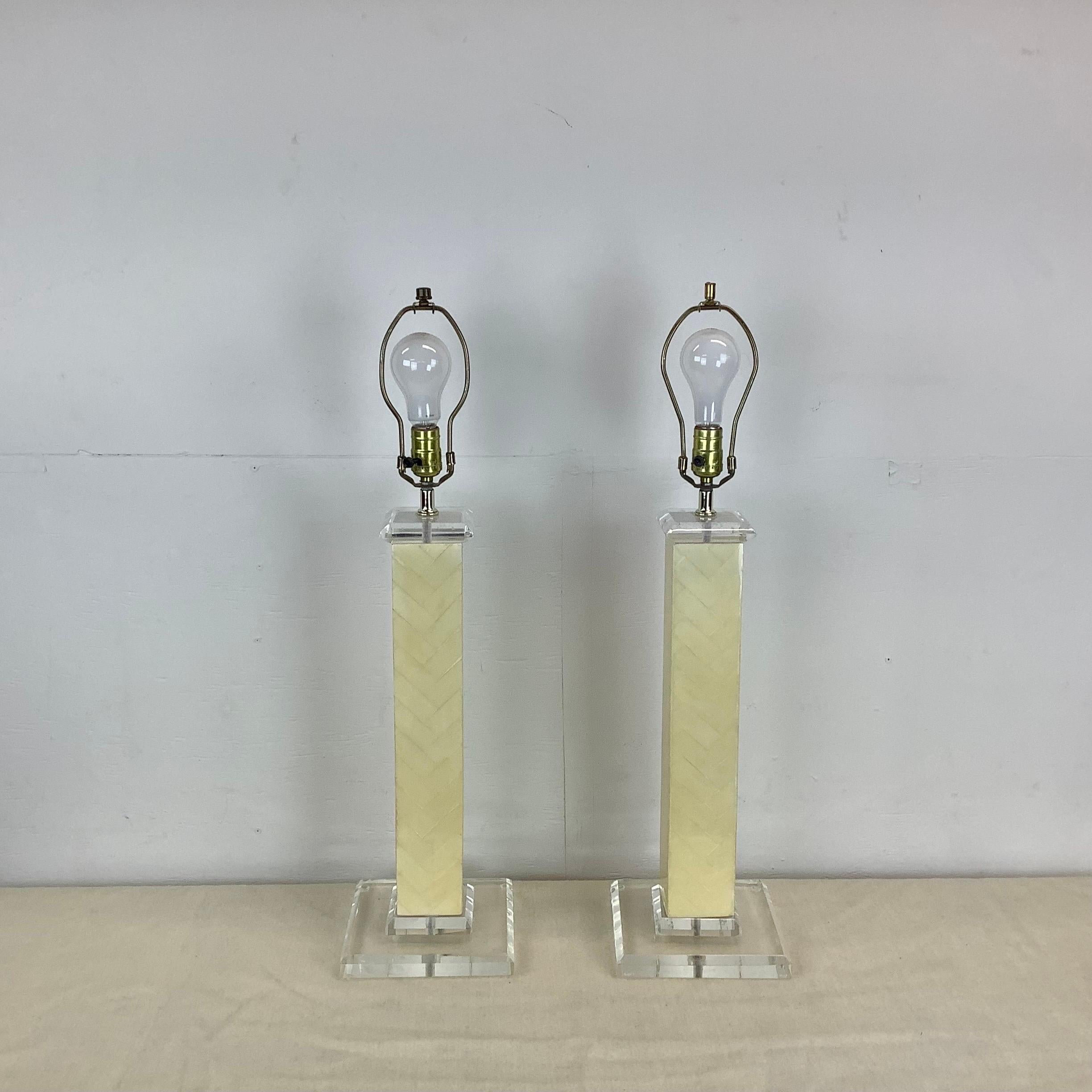 This impressive pair of tall vintage modern table lamps features a mixed material construction using clear lucite and lacquered tessellated bone-like finish. The elegant matching pair are perfect for home or office seating areas, bedside