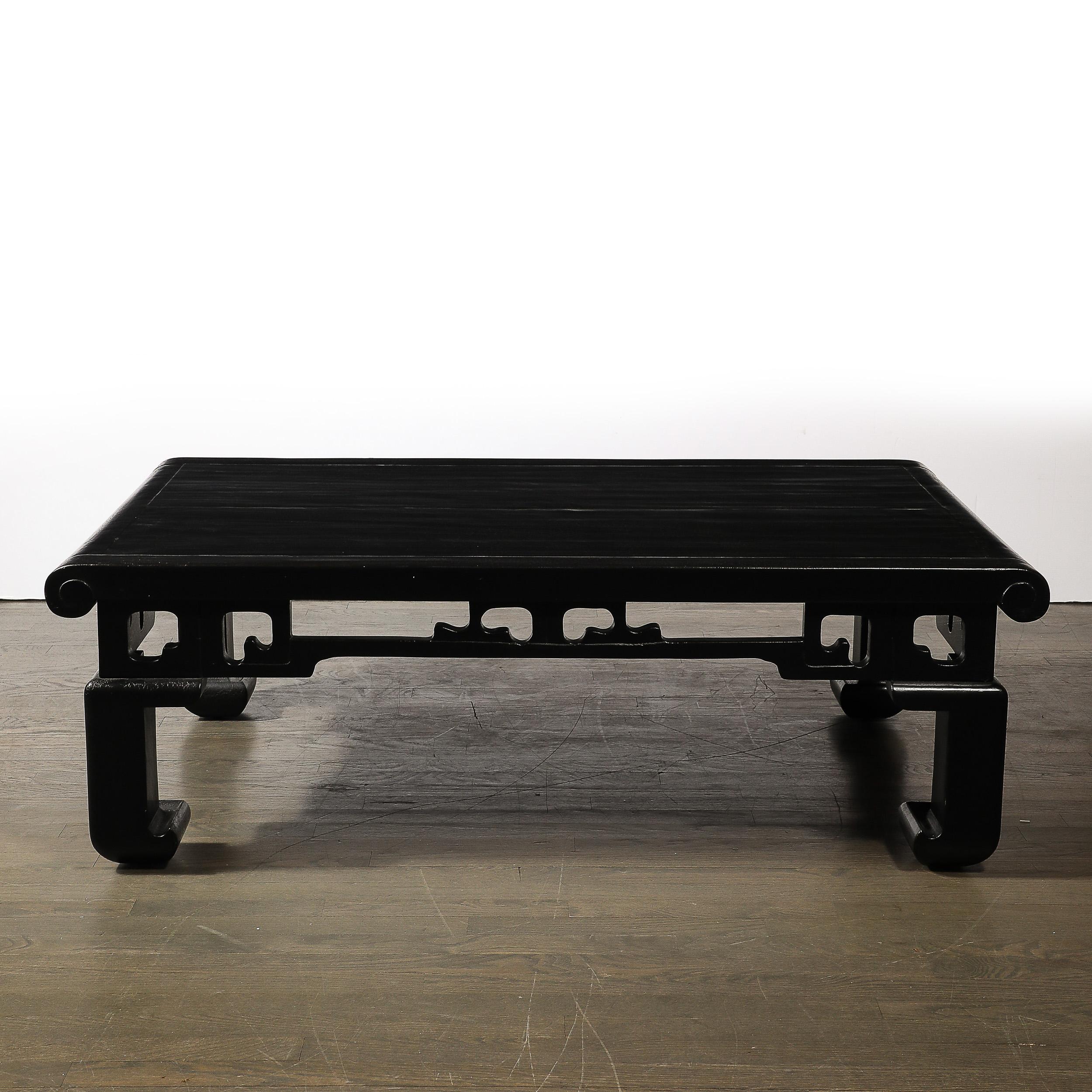 Améliorez votre espace de vie avec cette captivante table à cocktail moderniste du milieu du siècle. Fabriquée en noyer ébonisé texturé, cette pièce combine magnifiquement le design américain avec des motifs sculpturaux orientaux sur l'ensemble des
