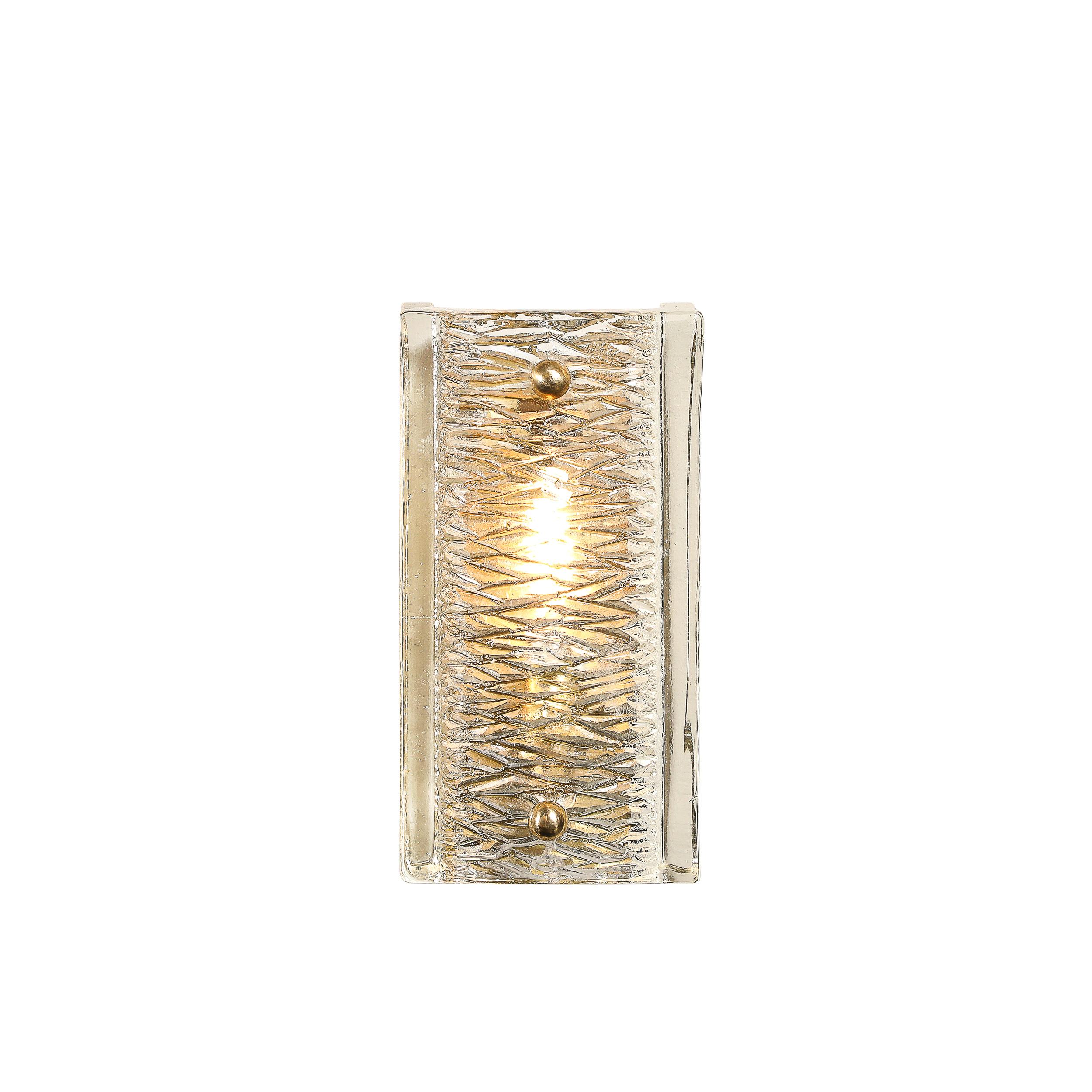 This highly elegant Pair of Mid-Century Modernist Sconces in Textured Glass W/ Brass Fittings by Carl Fagerlund for Orrefors originates from Sweden, Circa 1960. These sconces feature a minimal rectilinear profile of clear glass with two spherical
