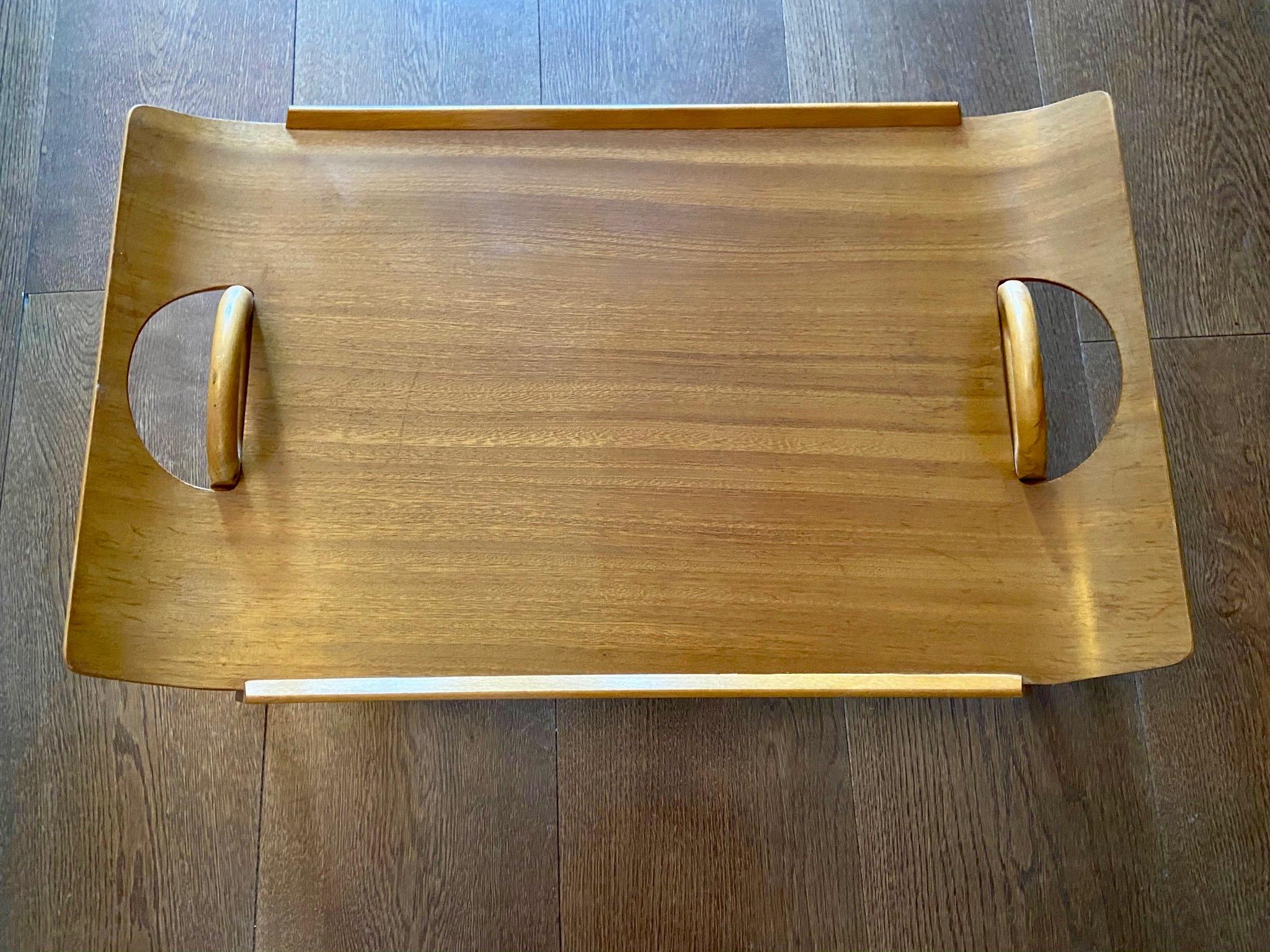 Centurion teak breakfast bed tray table by Paragon. From the 50s. This fine piece won the Good Housekeeping Design Award in 1957. The handles are pushed downwards on each sides, and folded beneath the tray. Can be used with the legs out or as a
