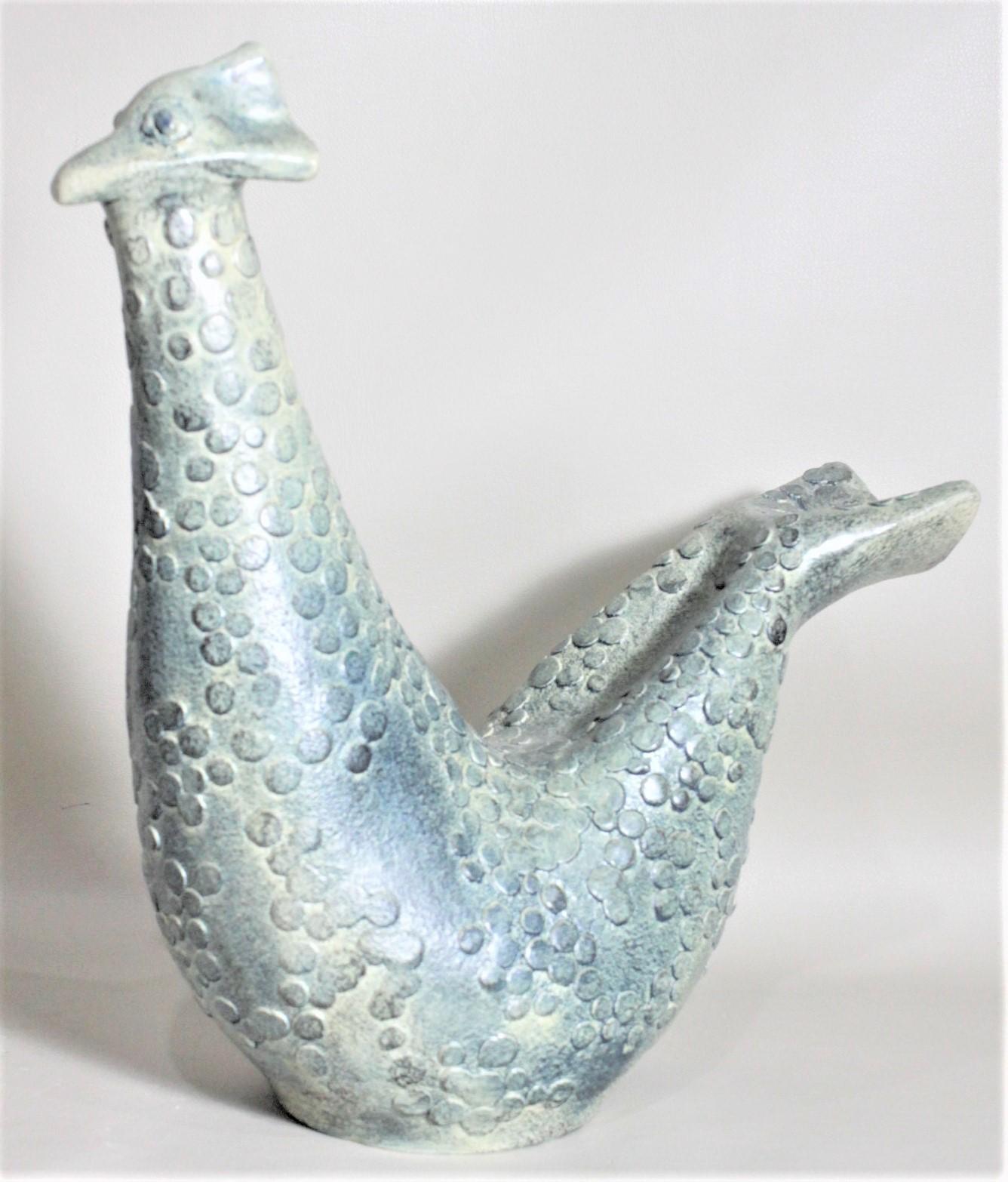 This unique and whimsical pottery bird sculpture was made by Theo and Susan Harlander of the Brooklin Pottery company of Canada in approximately 1965 in the period Mid-Century Modern style. The sculpture is a seated stylized bird with a whimsical