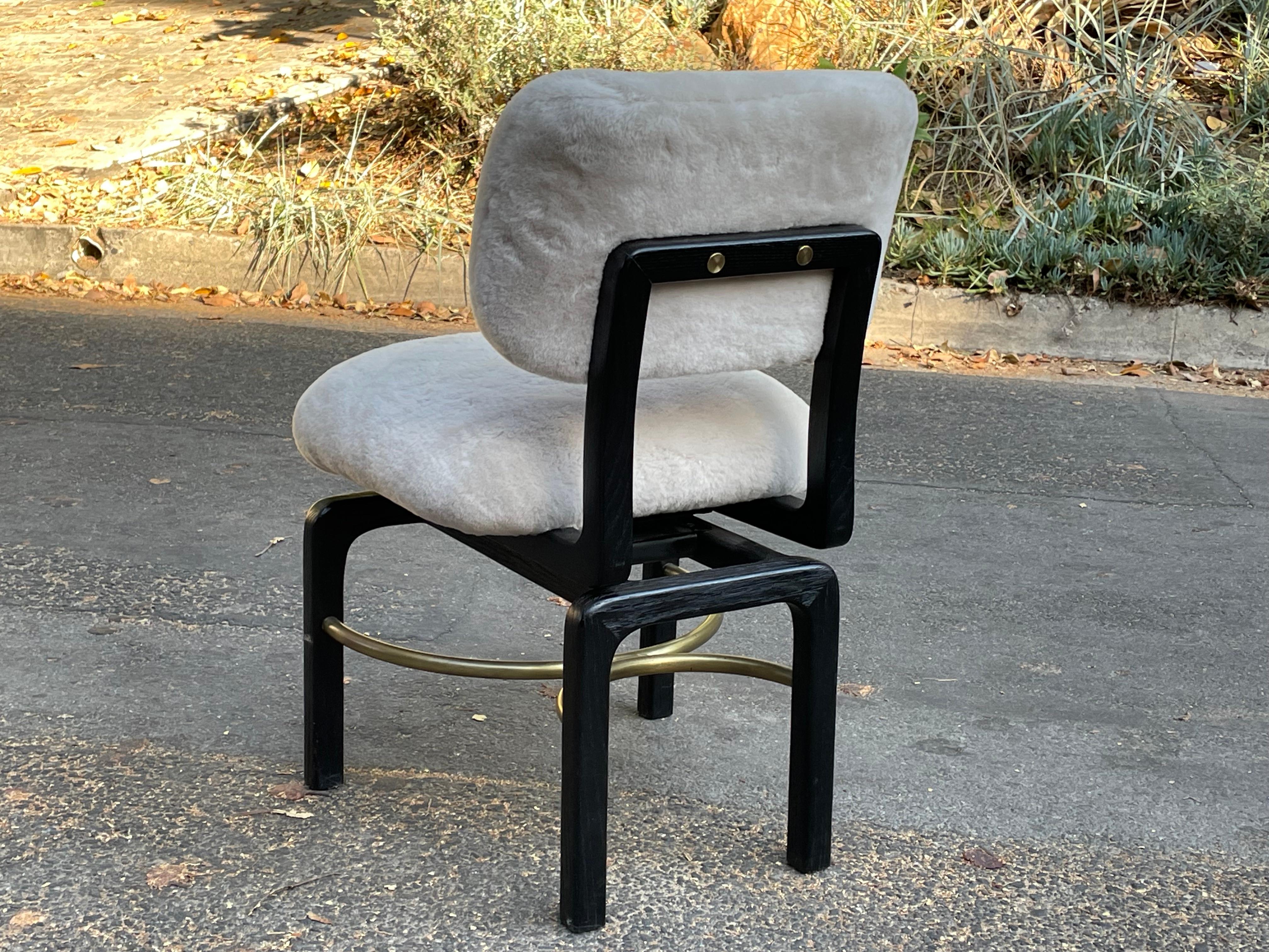 Superbe chaise d'appoint pivotante conçue sur mesure par Thomas/One Studio et recouverte de shearling sur l'assise et le dossier. Magnifique cadre en bois massif noir avec brancards en laiton.

Les lignes de cette chaise sont superbes.

Excellent