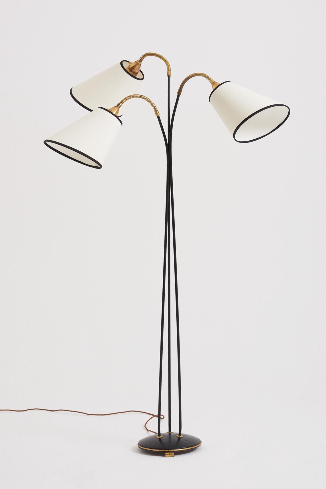 A brass and black enamelled three-armed floor lamp.
Sweden, 1950s
190 cm high by 78 cm wide by 60 cm depth, lamp base 25 cm diameter