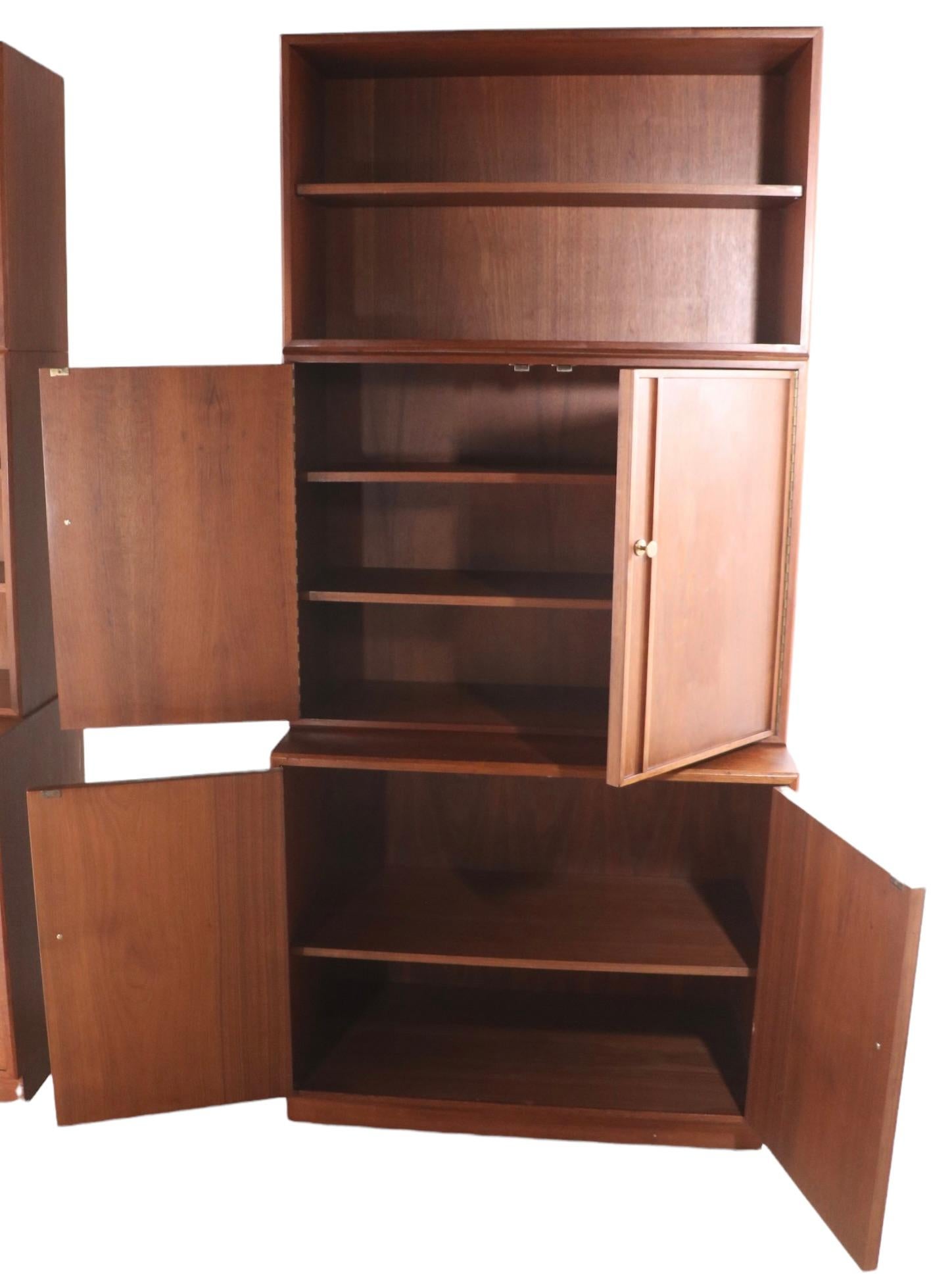 Impressive mid-century freestanding storage wall shelf unit manufactured by the West Michigan Furniture Company. The set includes three independent cabinets, two smaller side cabinets, and a larger ( wider ) center piece. Each cabinet consistent of