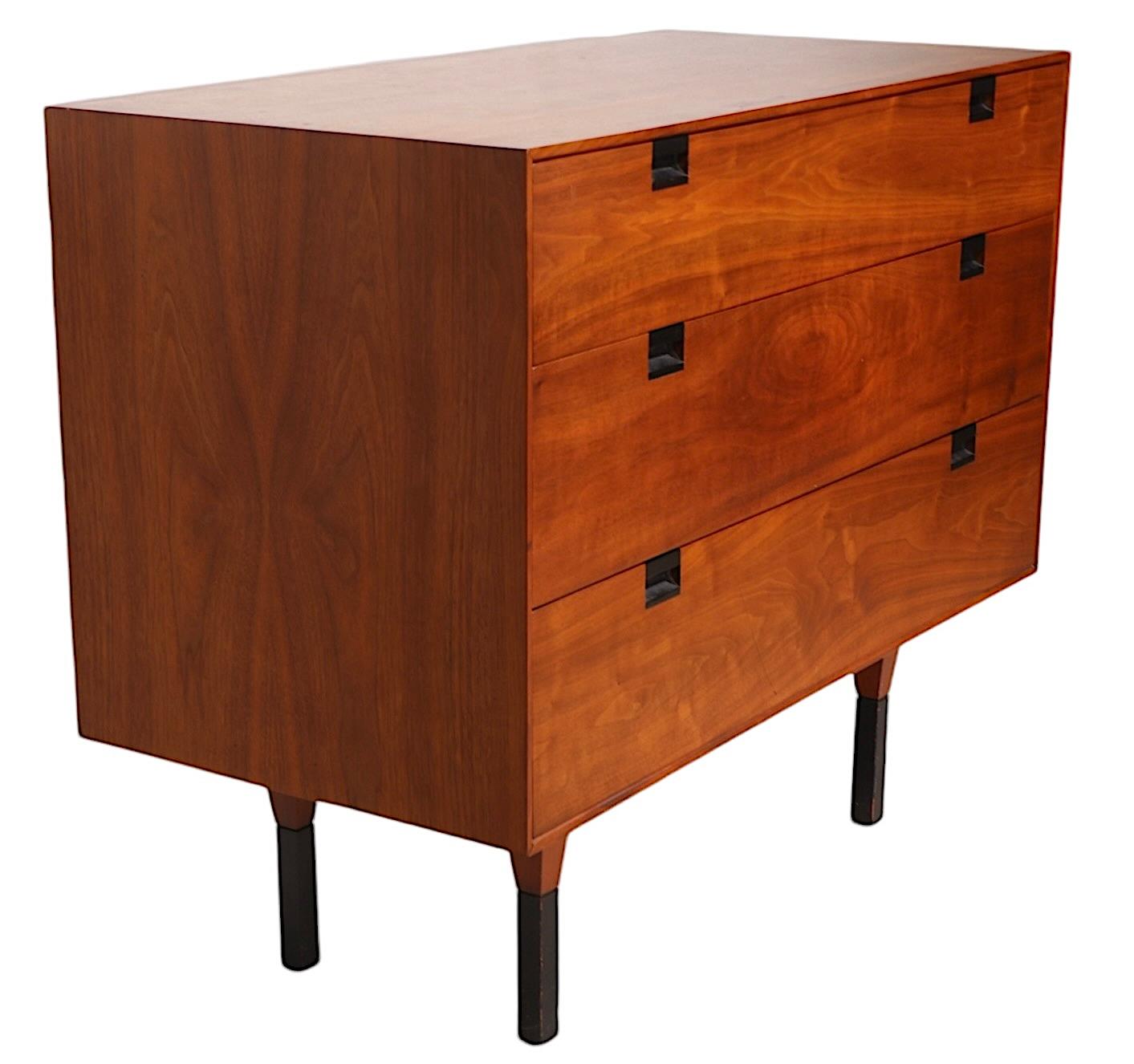 Rare Mid Century bachelors chest, design attributed to Milo Baughman for Directional Furniture, circa 1950/60's. The three drawer  chest features a walnut case with recessed ebonized drawer pulls, raised on an architectural base having tapering
