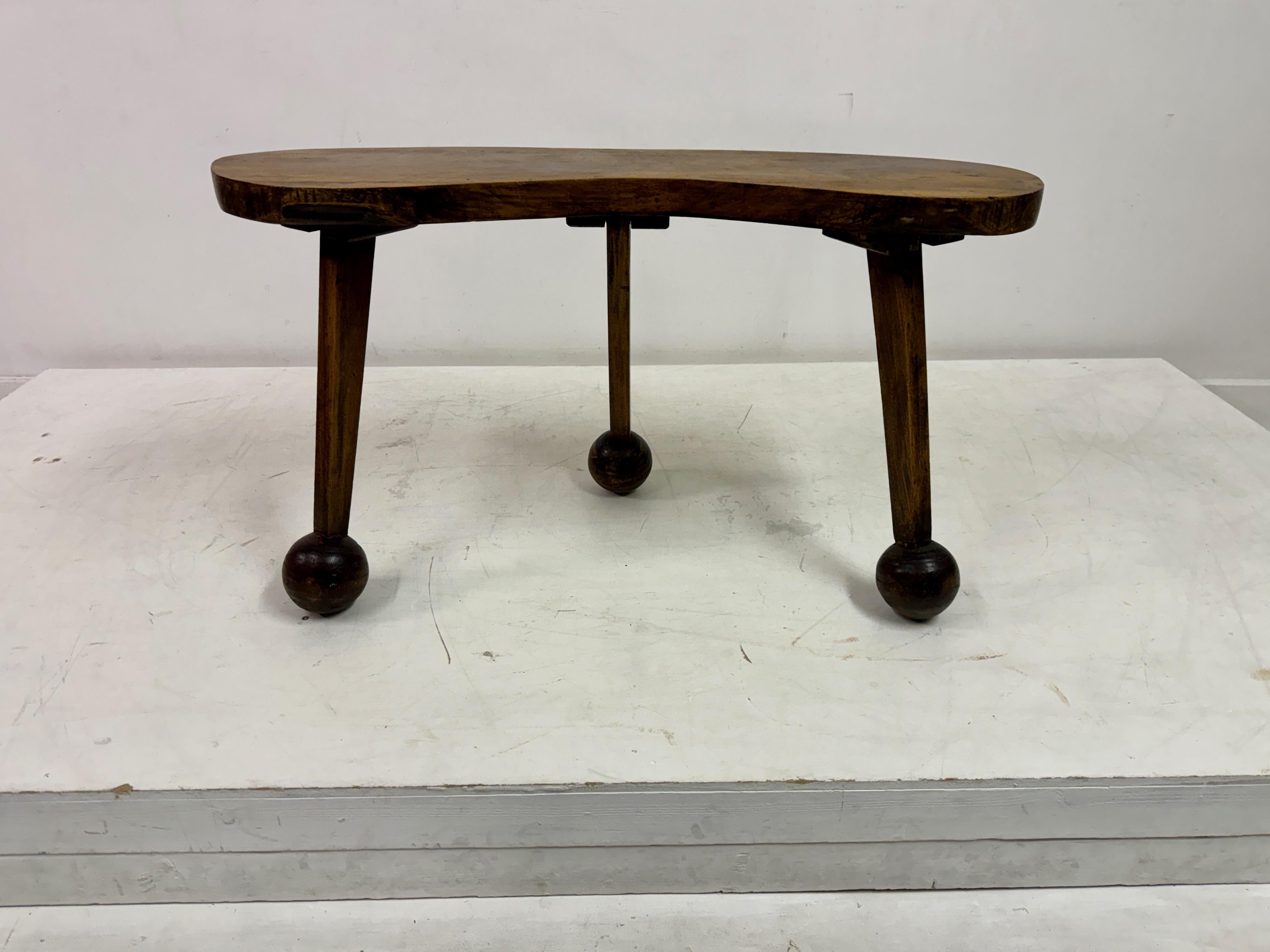 Coffee table or could be used as a bench

Rustic 

Irregular kidney-shaped top

Three legs

Wooden spherical feet

Mid century
