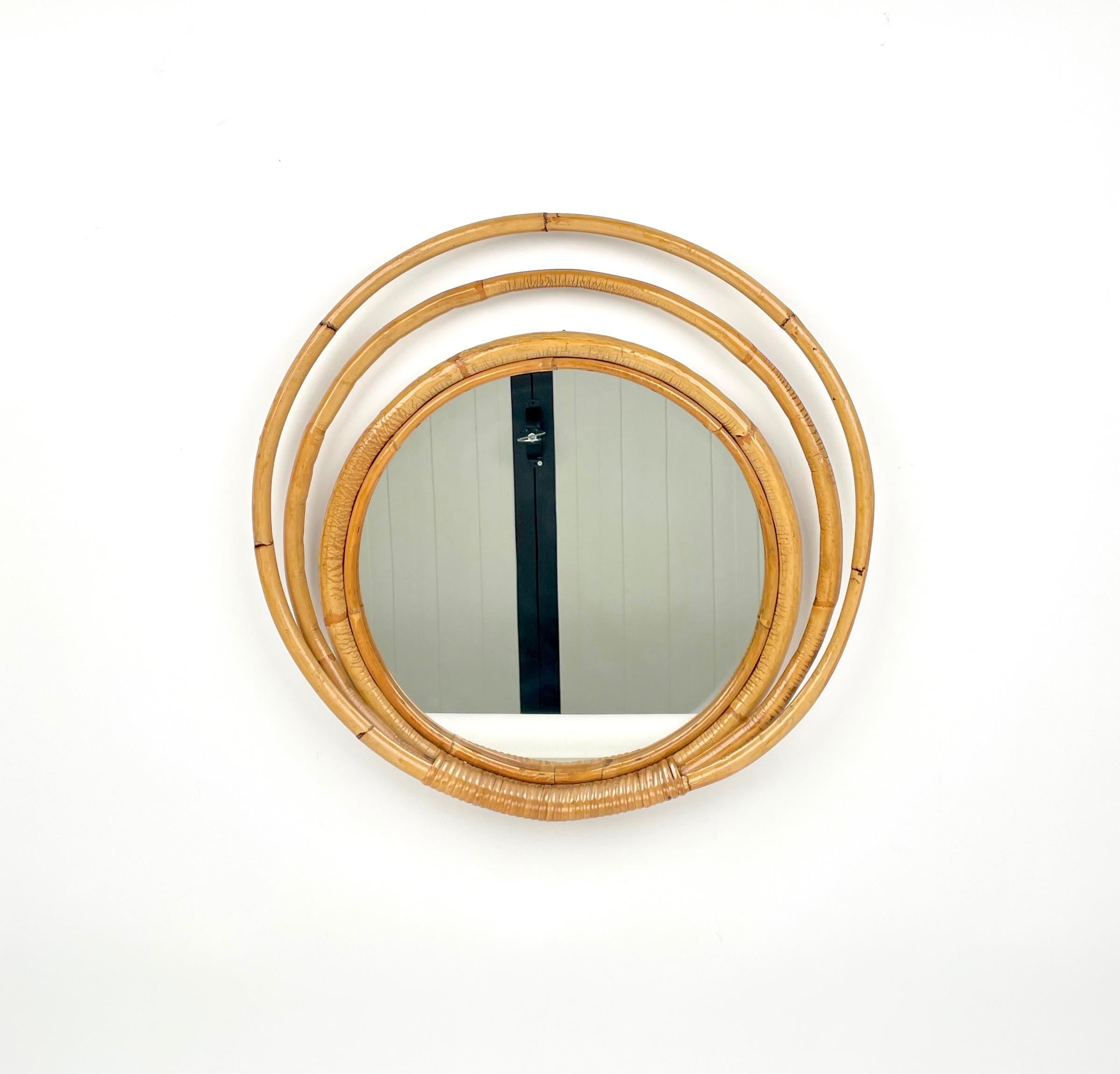 Specchio da parete rotondo incorniciato da cerchi di bambù e rattan a tre livelli, realizzato in Italia negli anni '60.
