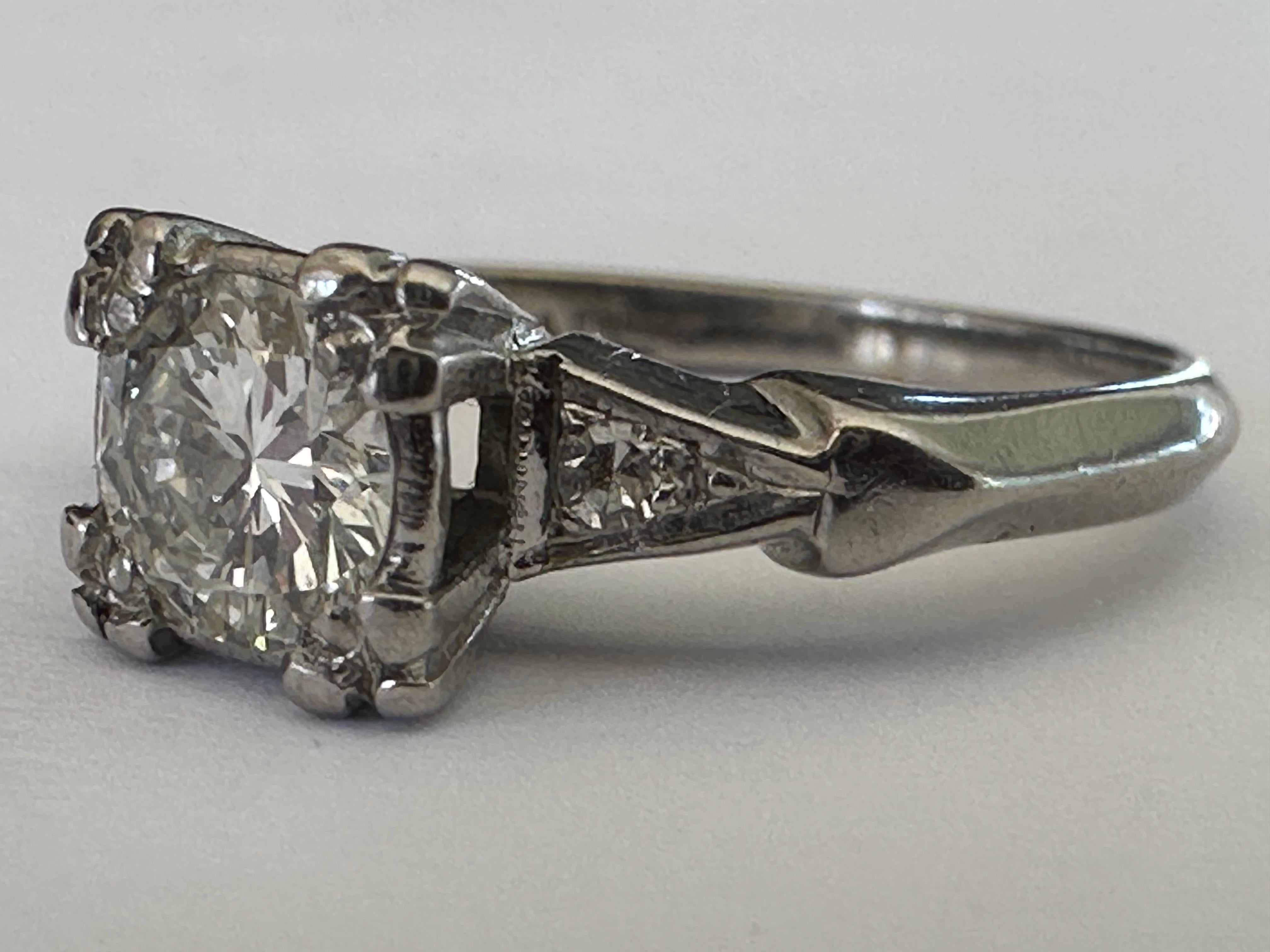 A bold Old European-cut diamond center stone totaling approximately 0.45 carat, F color VS1+ clarity and measuring 5mm, shines brilliantly between two single cut diamonds.  Set in palladium. This mid-century diamond three-stone ring was most likely