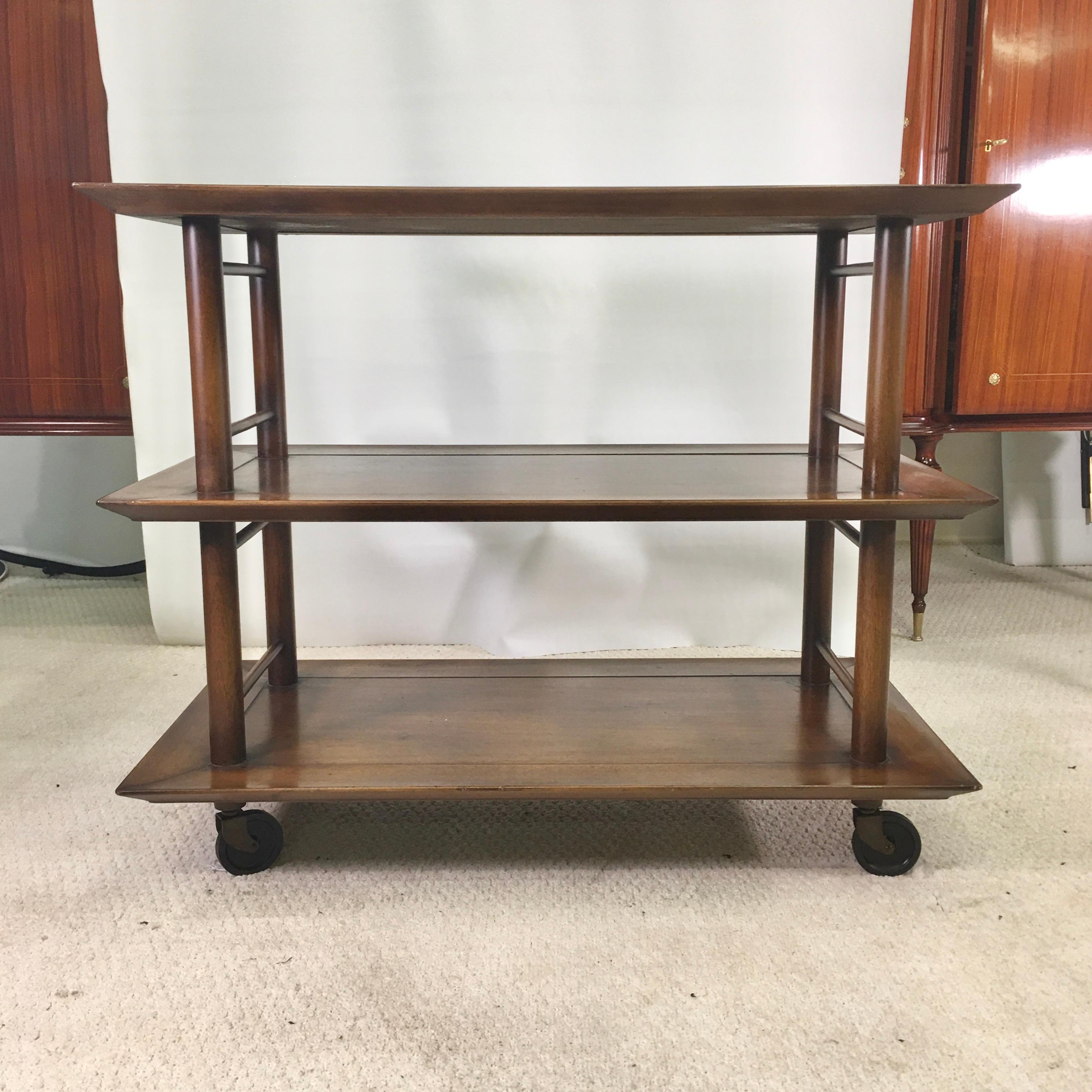 1950s three-tier walnut serving cart on casters. 11.5 inches height between tiers allowing for bottles to stand.

 
