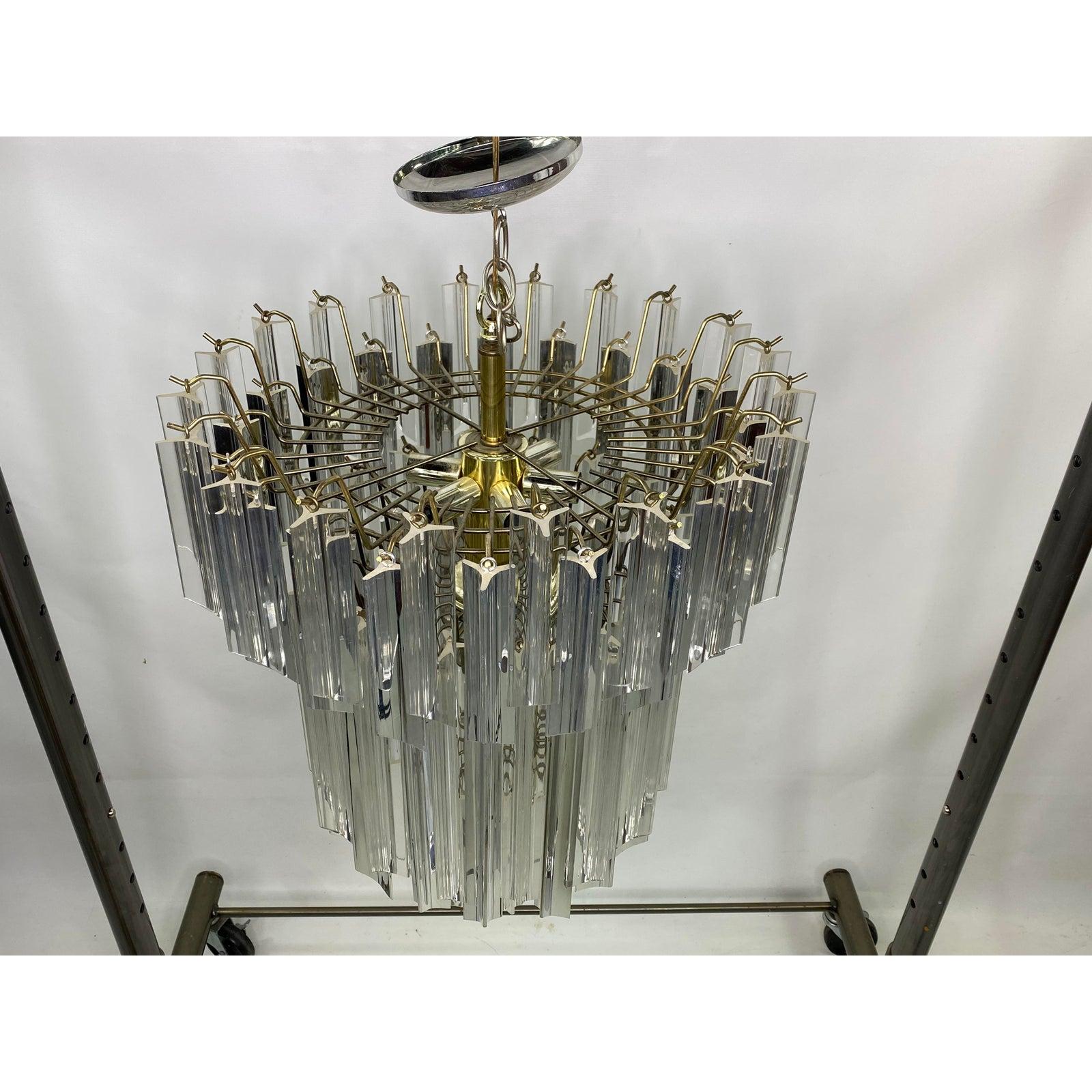 Mid-century three-tier lucite chandelier. Chandelier is missing one smaller lucite piece on bottom. It’s not very noticeable. Also some of the lucite is silver color.