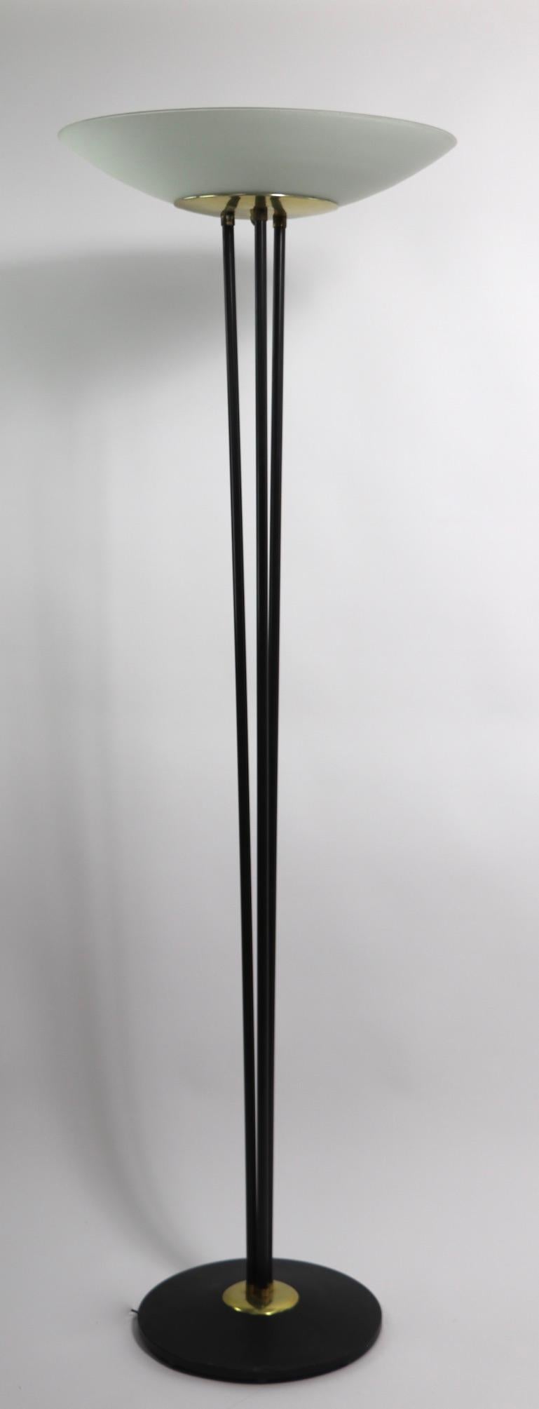 Classic mid century  torchiere floor lamp, designed by Gerald Thurston, for Lightolier. This stunning lamp features a black base from which emanate three rods that splay out and support a brass dish that holds the original glass dish shade. The