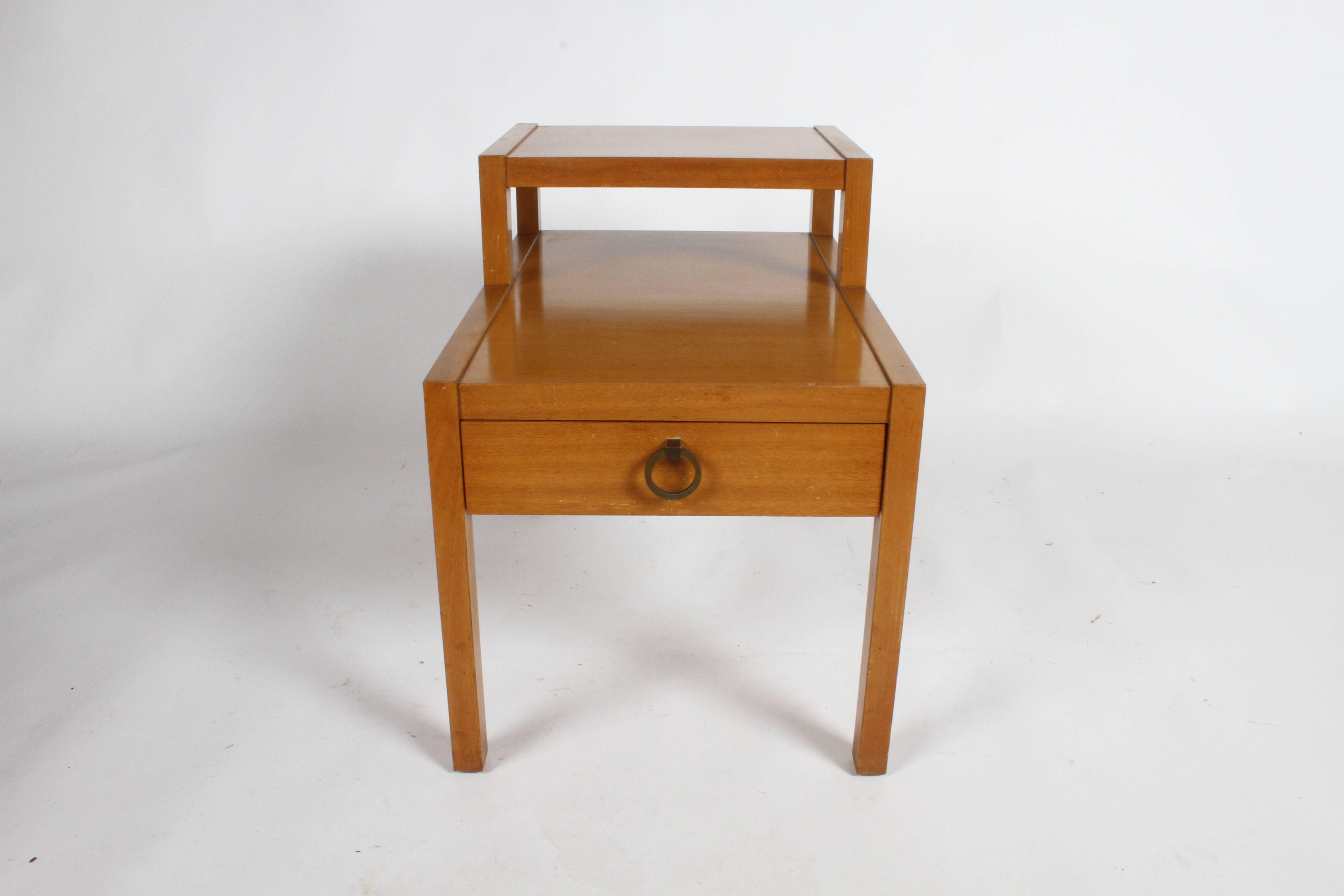 1950s Mid-Century Modern stepped or tiered mahogany end table with drawer and brass Asian style brass ring pull. Shown in original blonde finish, shows wear. Can be refinished for additional cost. T.H. Robsjohn-Gibbings did a similar design for