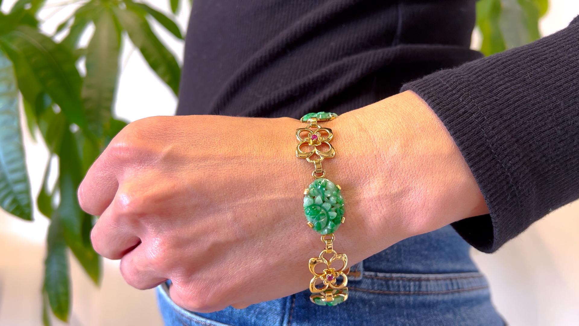 One Mid Century Tiffany & Co. Jade and Ruby 14k Yellow Gold Bracelet. Featuring three pieces of carved jade. Accented by four round mixed cut rubies with a total weight of approximately 0.25 carat. Crafted in 14 karat yellow gold, signed Tiffany &