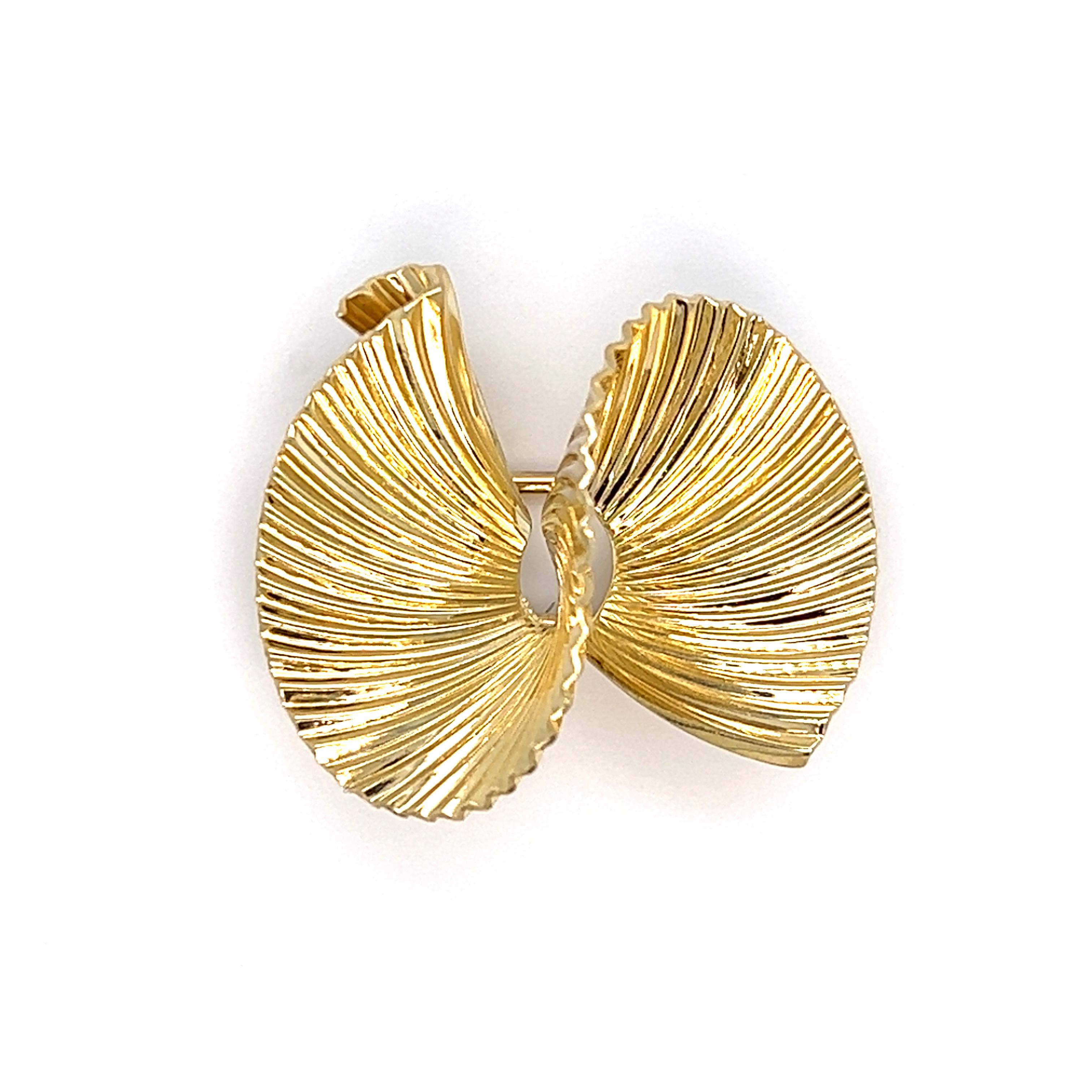One 14 karat yellow gold ribbon design pin by Tiffany & Co. (signed Tiffany & Co.) measuring 1.1 inch wide and is complete with a traditional pin closure.  