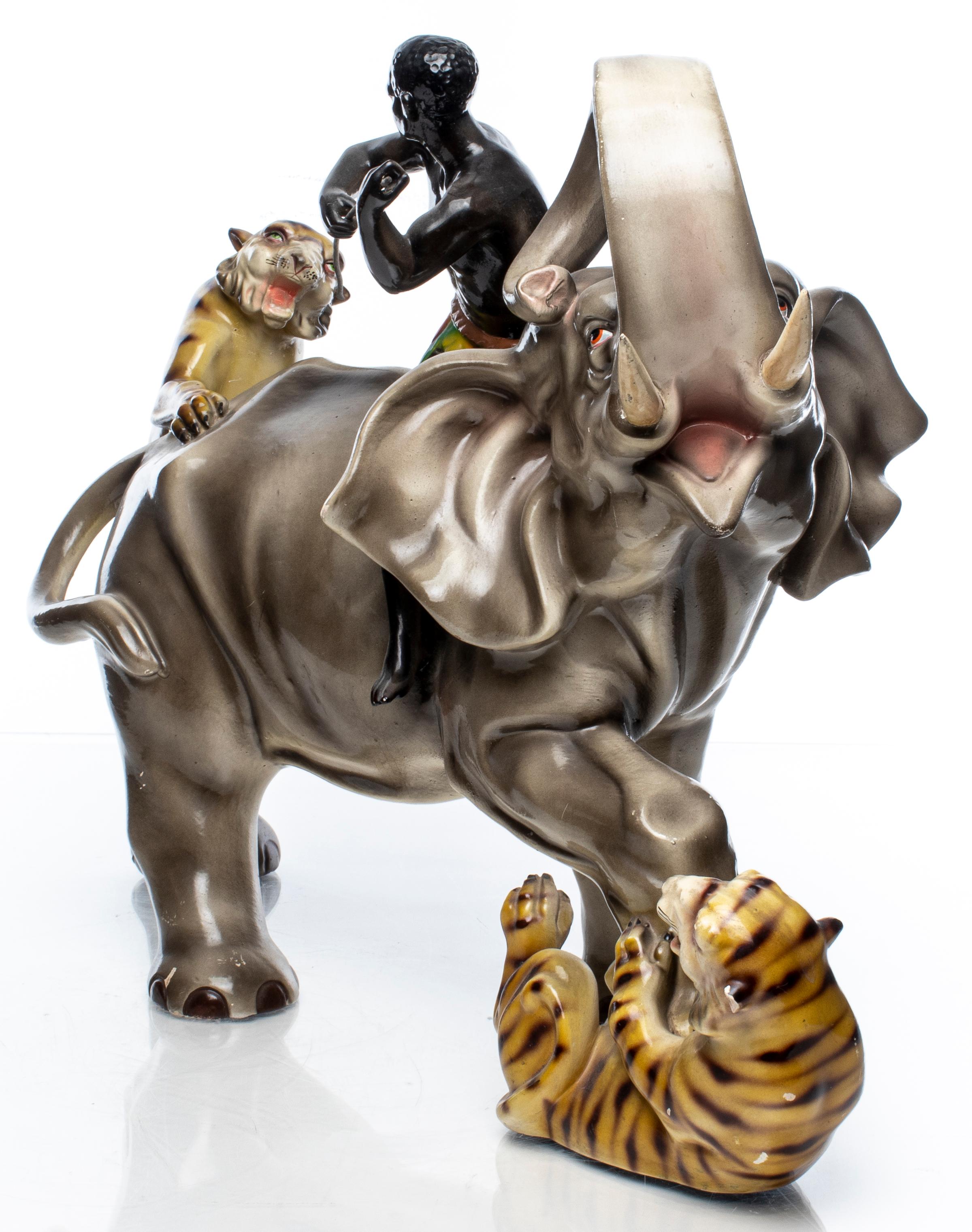 Large ceramic model of an elephant and man attacked by tigers, unsigned. Measures: 16” H x 22.5” W x 11.5” D.