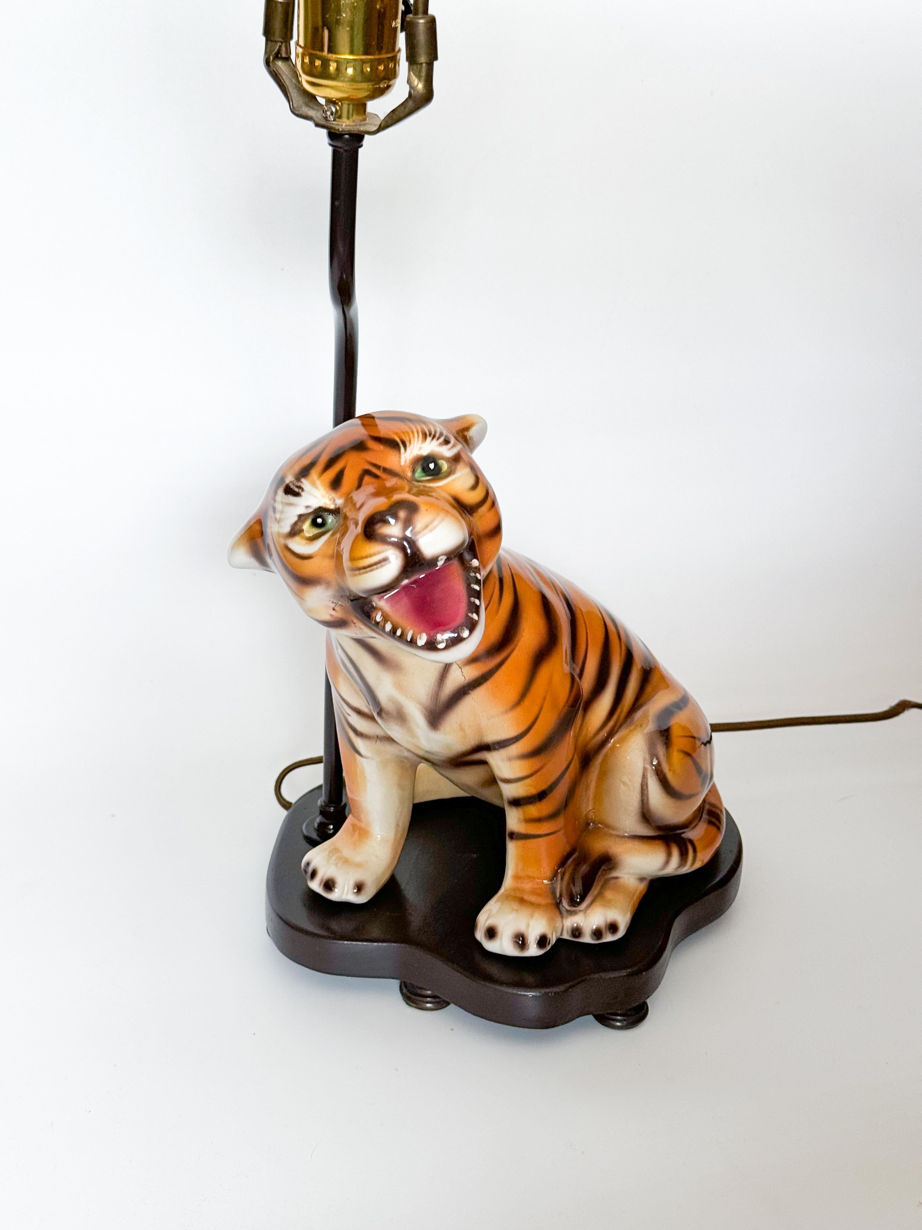 La lámpara de sobremesa de cerámica Tigre de mediados de siglo, fabricada por CLF Faiancas en Alcobaça, Portugal, durante la década de 1970, es un hallazgo extraordinario. La lámpara muestra un tigre de cerámica meticulosamente detallado, pintado a