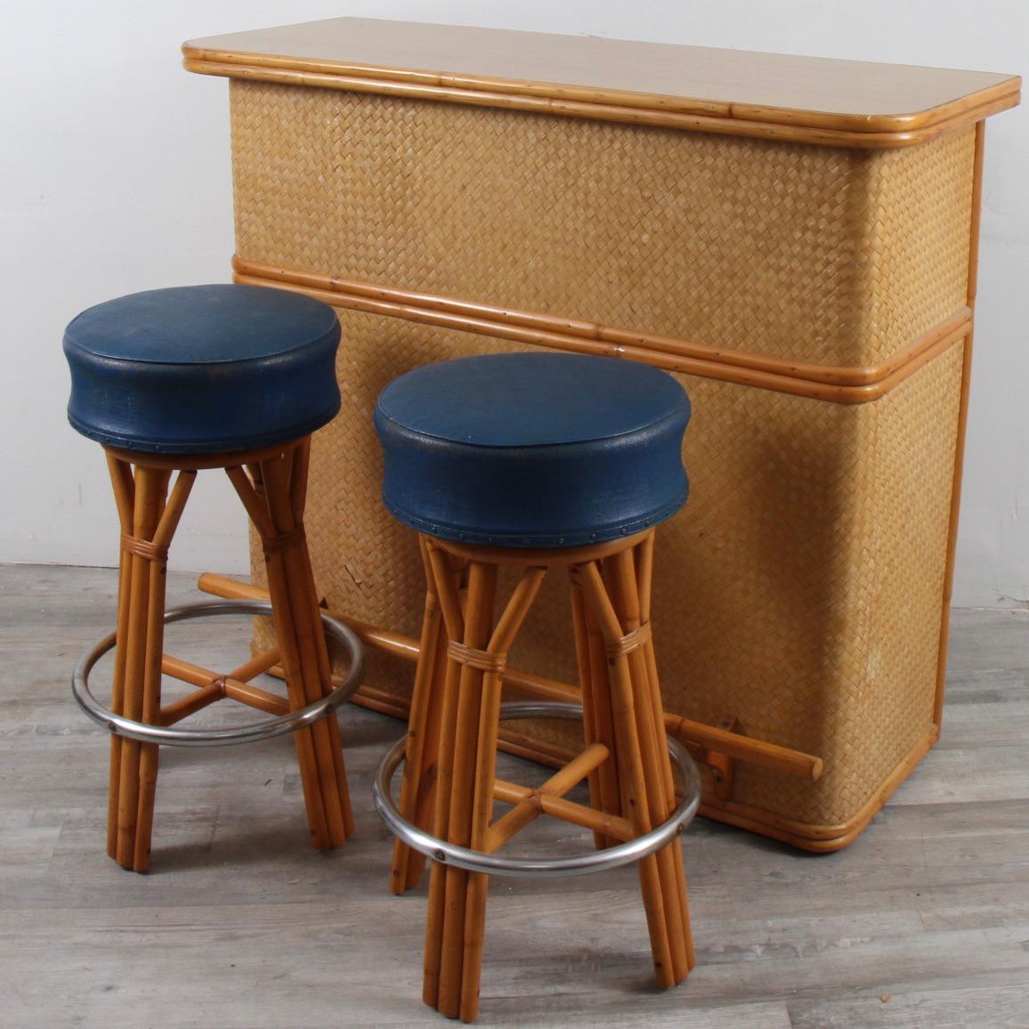 Iconic tiki-style bar with two original matching swivel stools. A fixture of man 50's and 60's basements, this set is clean, sturdy and ready for another 50 years of entertaining. Stools have a 30