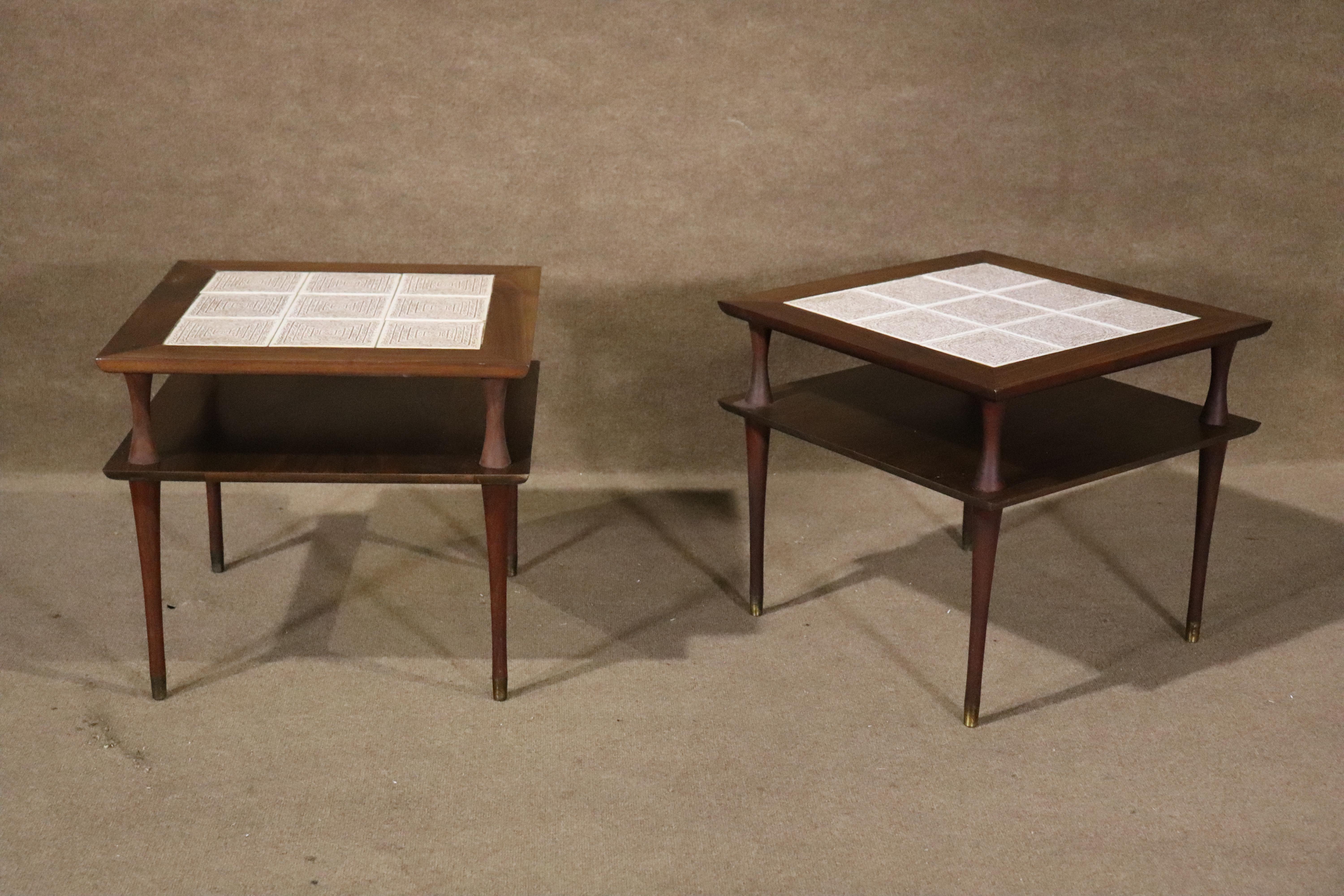 Pair of two tier side tables with patterned tile tops. Slender legs with brass tips, walnut grain throughout.
Please confirm location NY or NJ