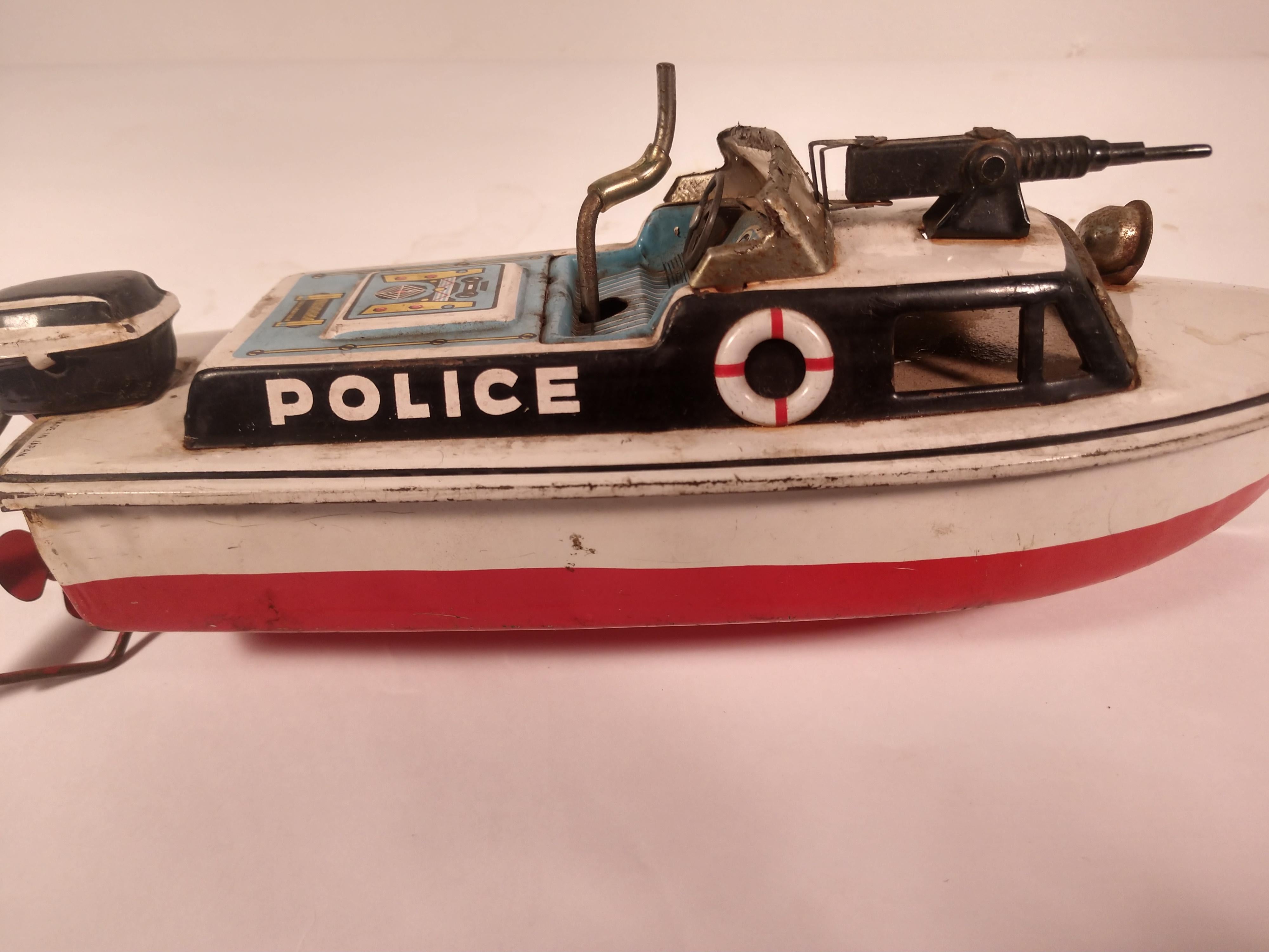Japanese windup police boat working effortlessly. Made in japan during the height it the tin toy era, late fifties, has survived and is ready for action. Great features including it's machine gun and searchlight which are just ornamental. Rust free