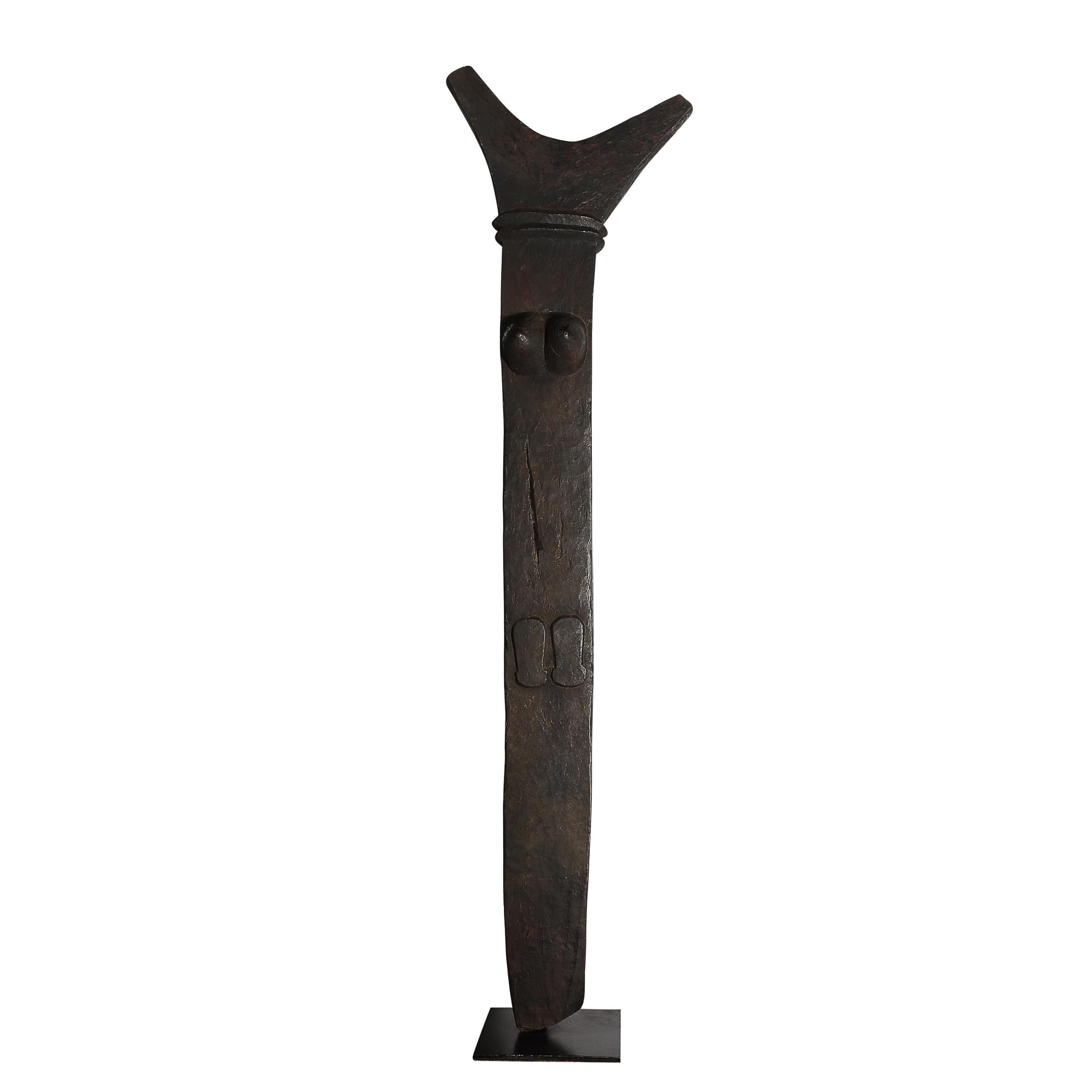 Questa affascinante scultura Toguna di metà secolo, realizzata dal popolo Dogon del Mali, riflette il ricco patrimonio culturale e le tradizioni artistiche dell'Africa occidentale. Scolpita in quercia bruciata, la scultura poggia su una robusta base