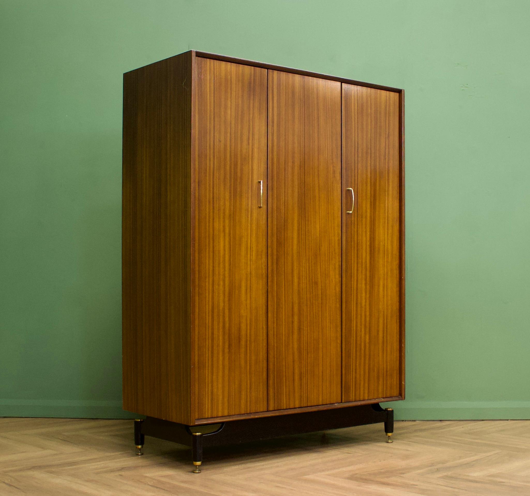 A mid century three door Tola and Black wardrobe from G Plan (EGomme)
Featuring a bi fold door and a rail the full width


This wardrobe dismantles