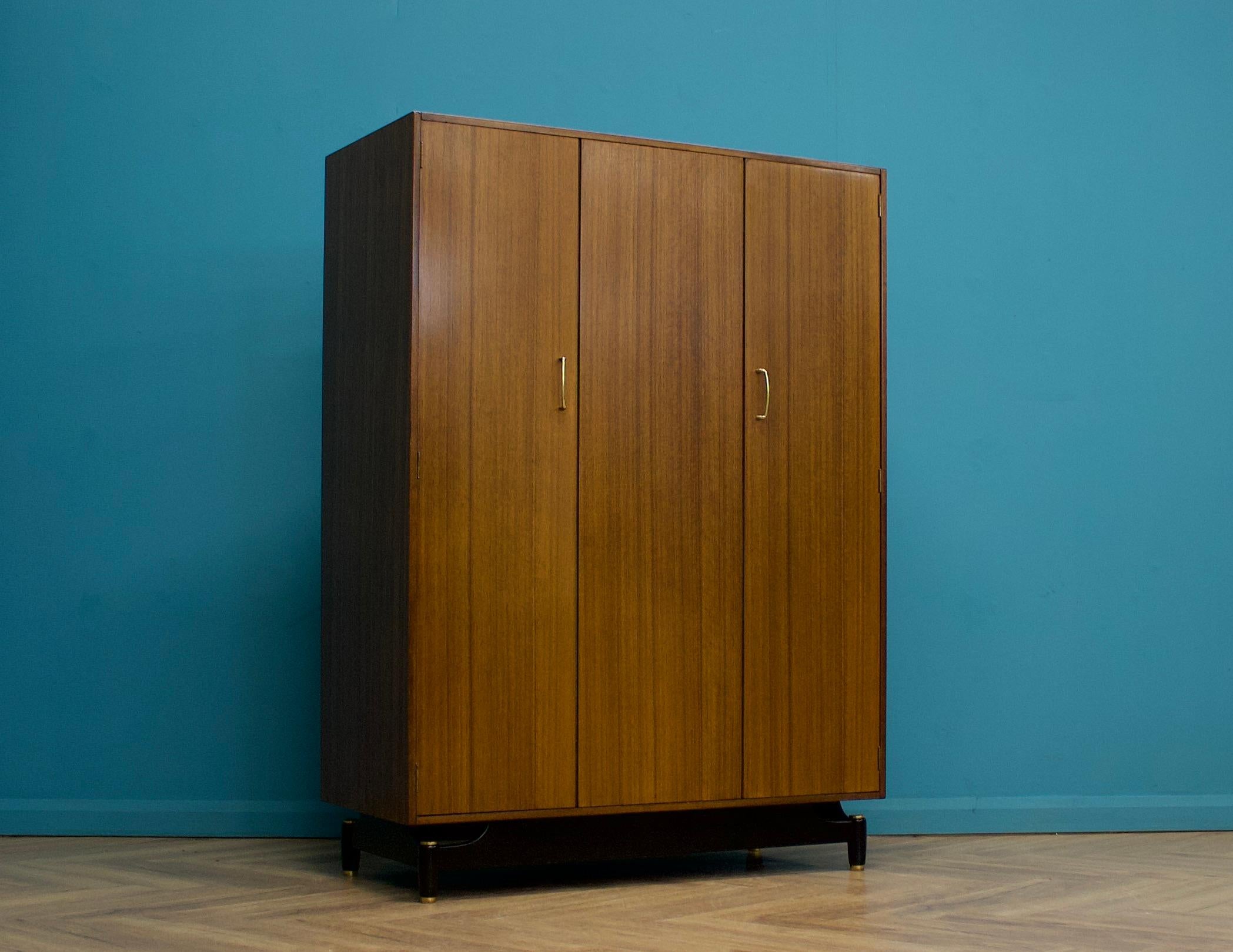 Ein dreitüriger Kleiderschrank aus der Mitte des Jahrhunderts in Tola und Schwarz von G-Plan (EGomme)
Ausgestattet mit einer Doppelfalttür und einer Schiene über die gesamte Breite


Diese Garderobe zerlegt