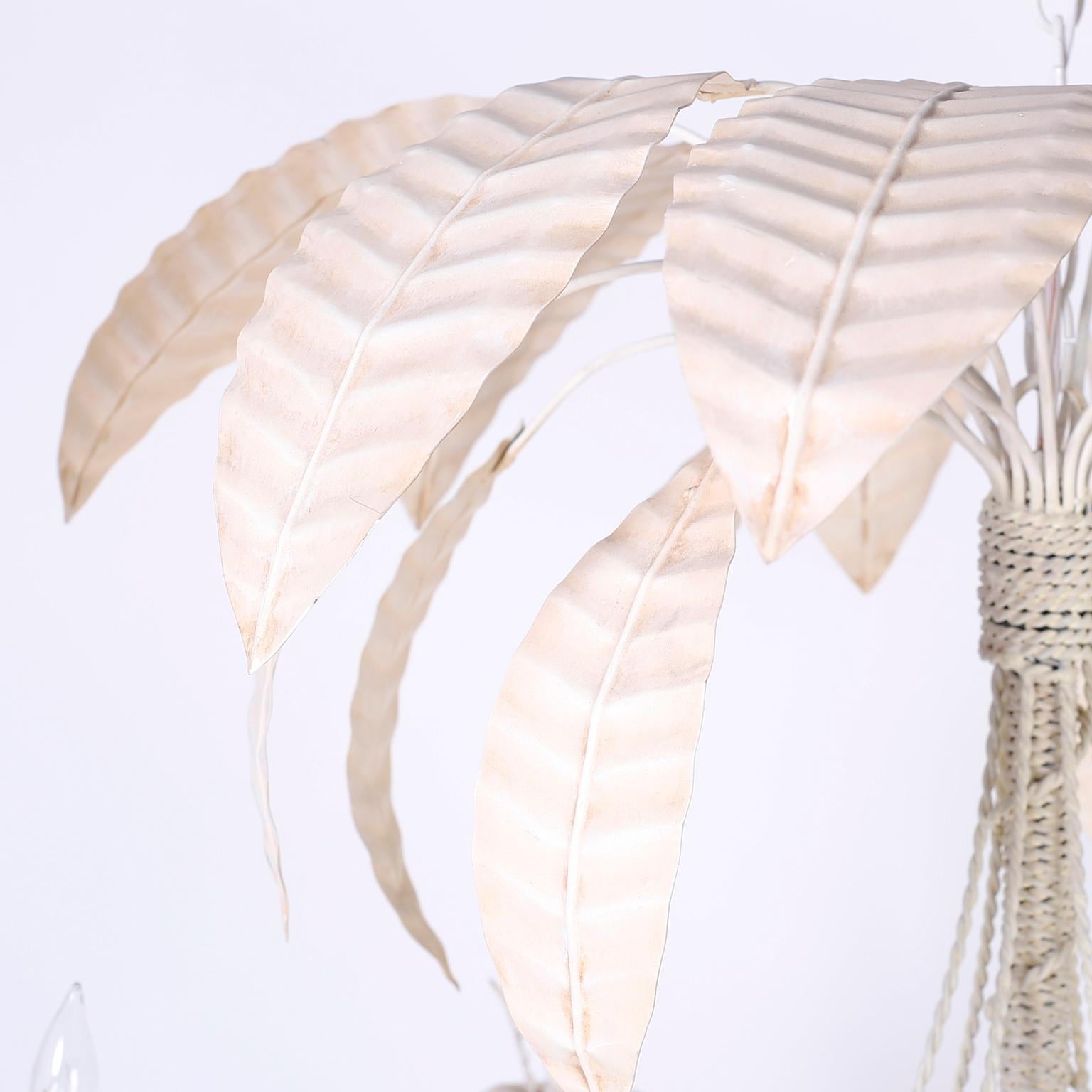 Midcentury Italian tole chandelier in white with a hip tropical vibe. Featuring palm fronds at the top wrapped in metal string, attached to six graceful arms with leaf candle cups.