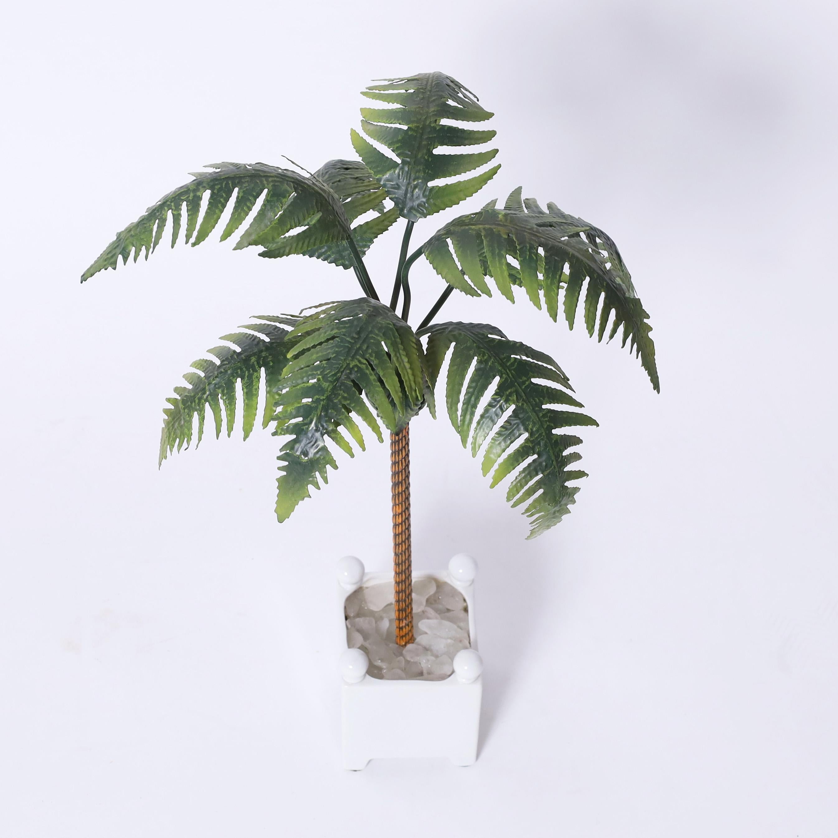 Chic vintage Italian palm tree object of art having tole leaves on a brass trunk in a classical porcelain planter with quartz stones.
