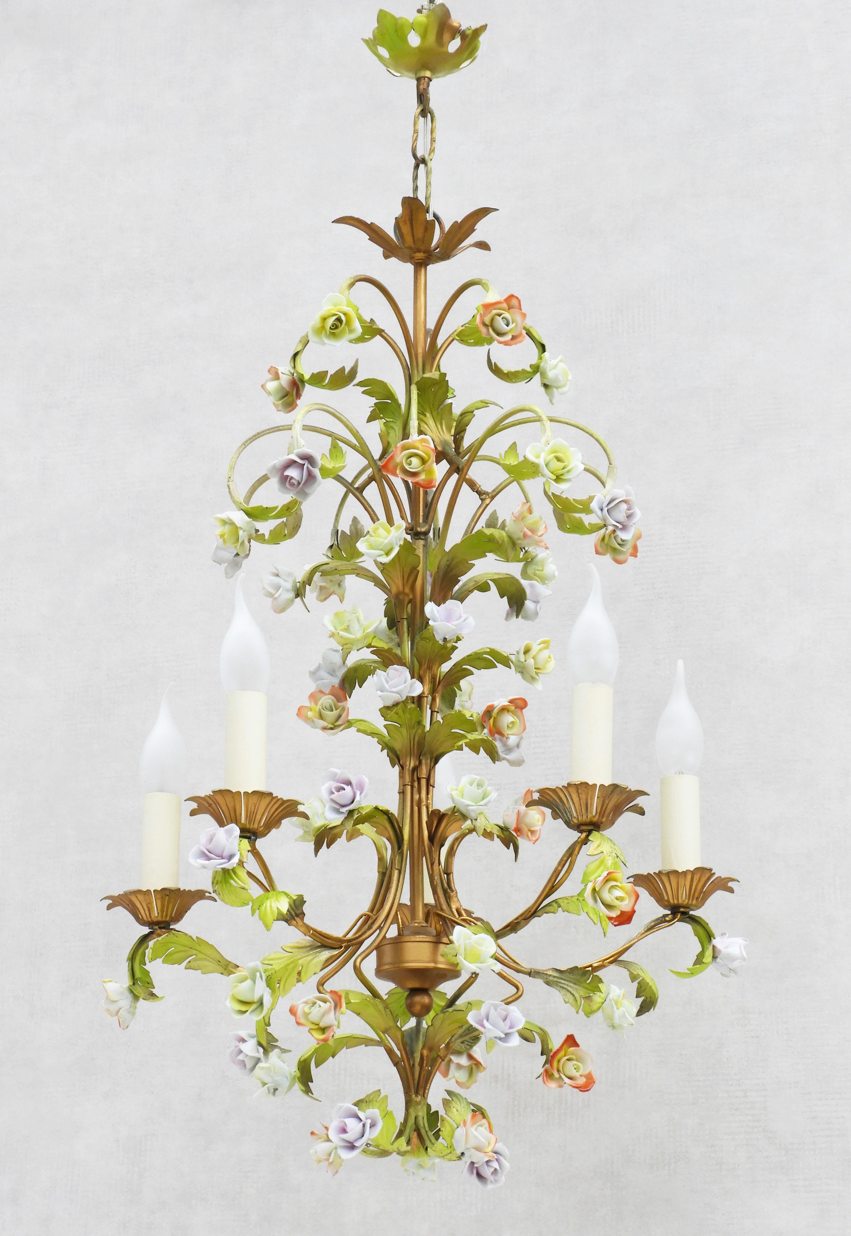 A pretty French midcentury painted tole chandelier with 55 hand-crafted rose flowers and five 'faux' candle lights all nestling amongst green and gold scrolling foliage.
In good vintage condition, completely rewired with all new electrical