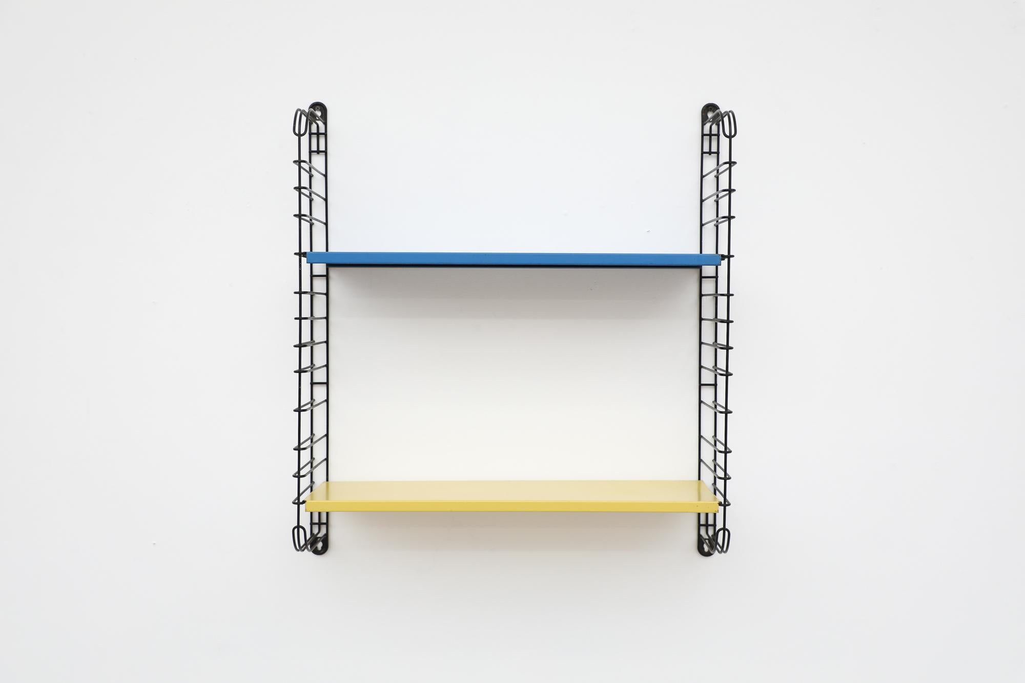 Midcentury Tomado Industrial shelving with blue and yellow shelves on black enameled metal wire risers. Designed by Jan Van Der Togt. The shelves rest on the wire risers and can be arranged to different positions. In original condition with visible