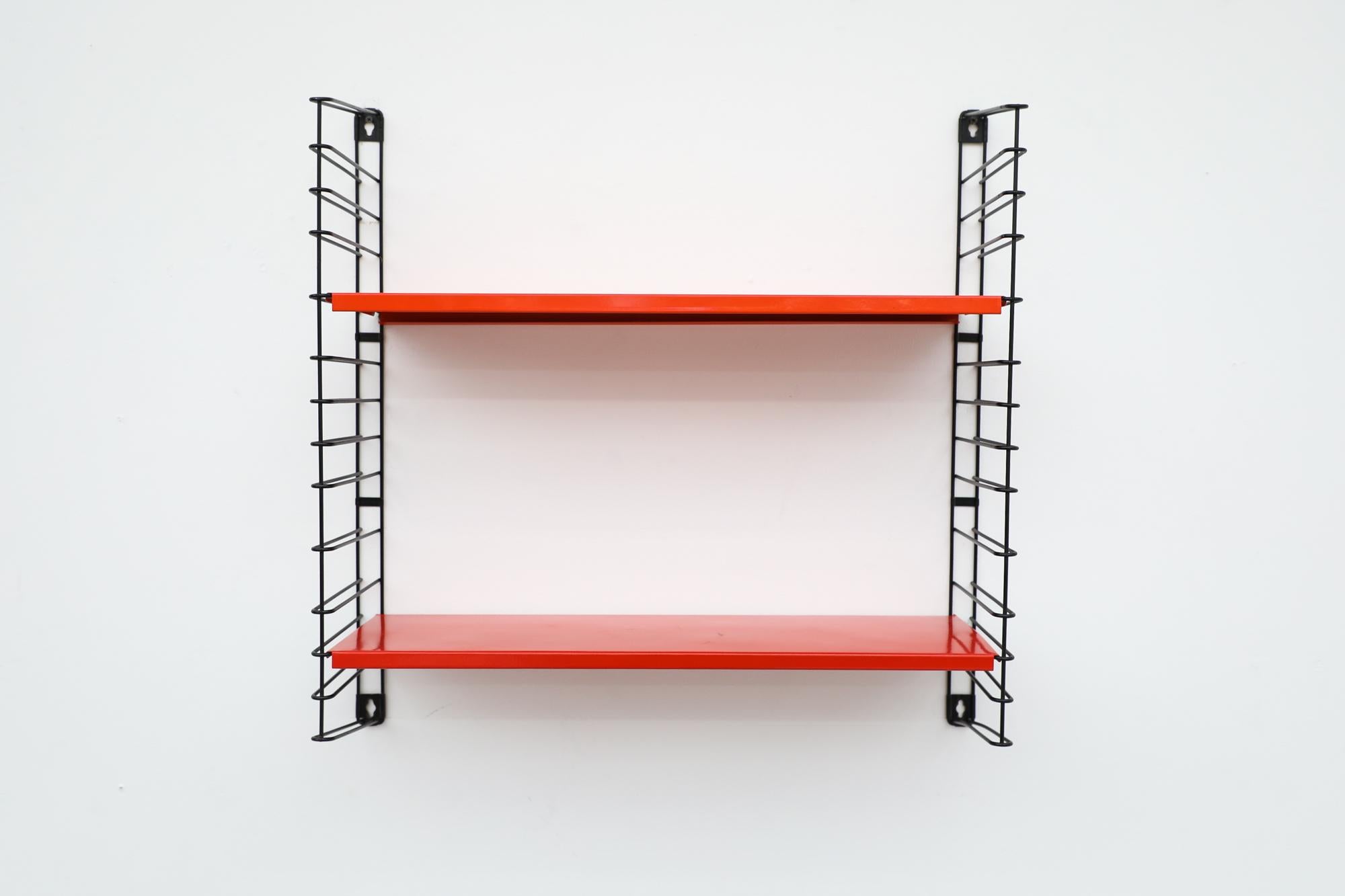 Midcentury TOMADO industrial shelving with red and orange shelves on black enameled metal wire risers. Designed by Jan van der Togt. Both shelves rest on the wire risers and can be arranged to different heights. The shelves and risers have all been