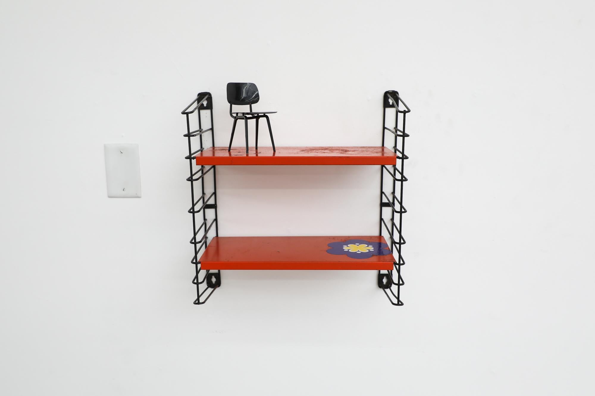 Mid-Century Tomado industrial shelving unit with red sheet metal shelves on black enameled wire risers. One shelf comes with a flower sticker! In original condition with some visible wear and enamel loss consistent with age and use. Other similar
