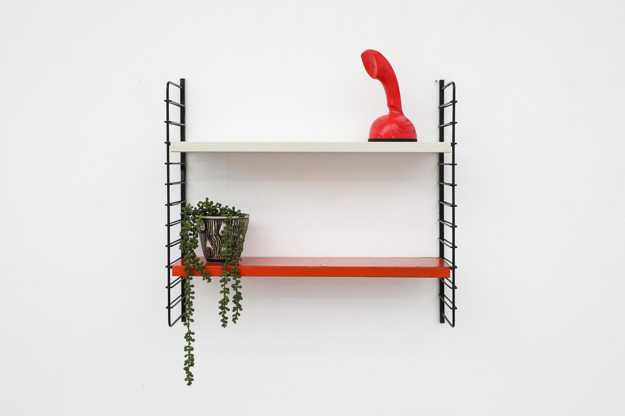 Mid-Century, Tomado style industrial shelving with Red and Grey shelves on black enameled metal wire risers. The shelves rest on the wire risers and can be arranged to different positions. In original condition with visible wear and scratching