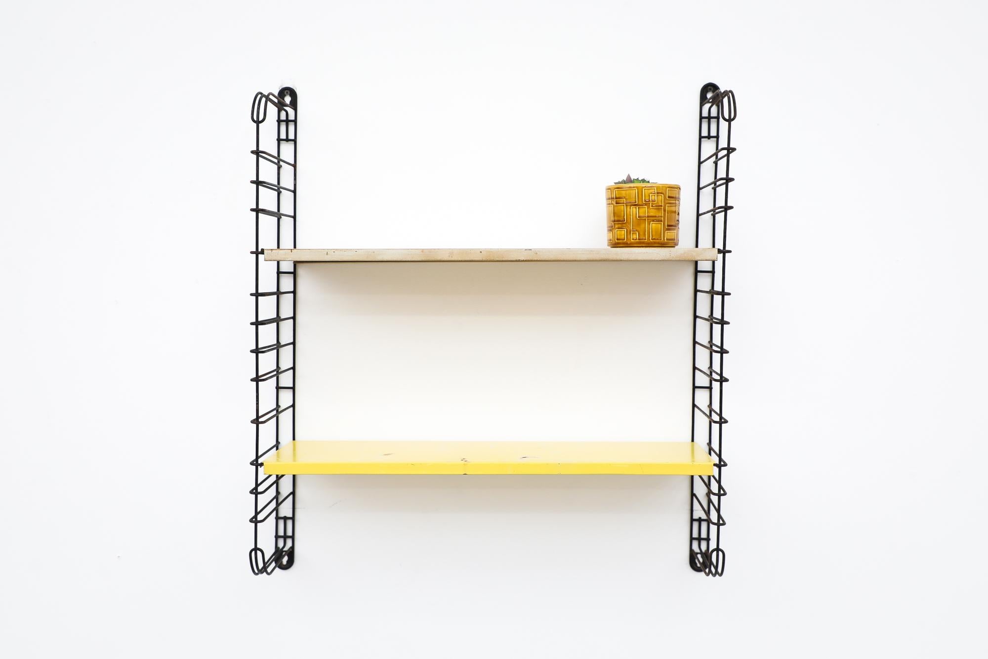 Midcentury TOMADO industrial shelving with very worn white and a sunshine yellow enameled metal shelves on black metal wire risers. Designed by Jan van der Togt. The shelves rest on the wire risers and can be arranged to different heights. In very