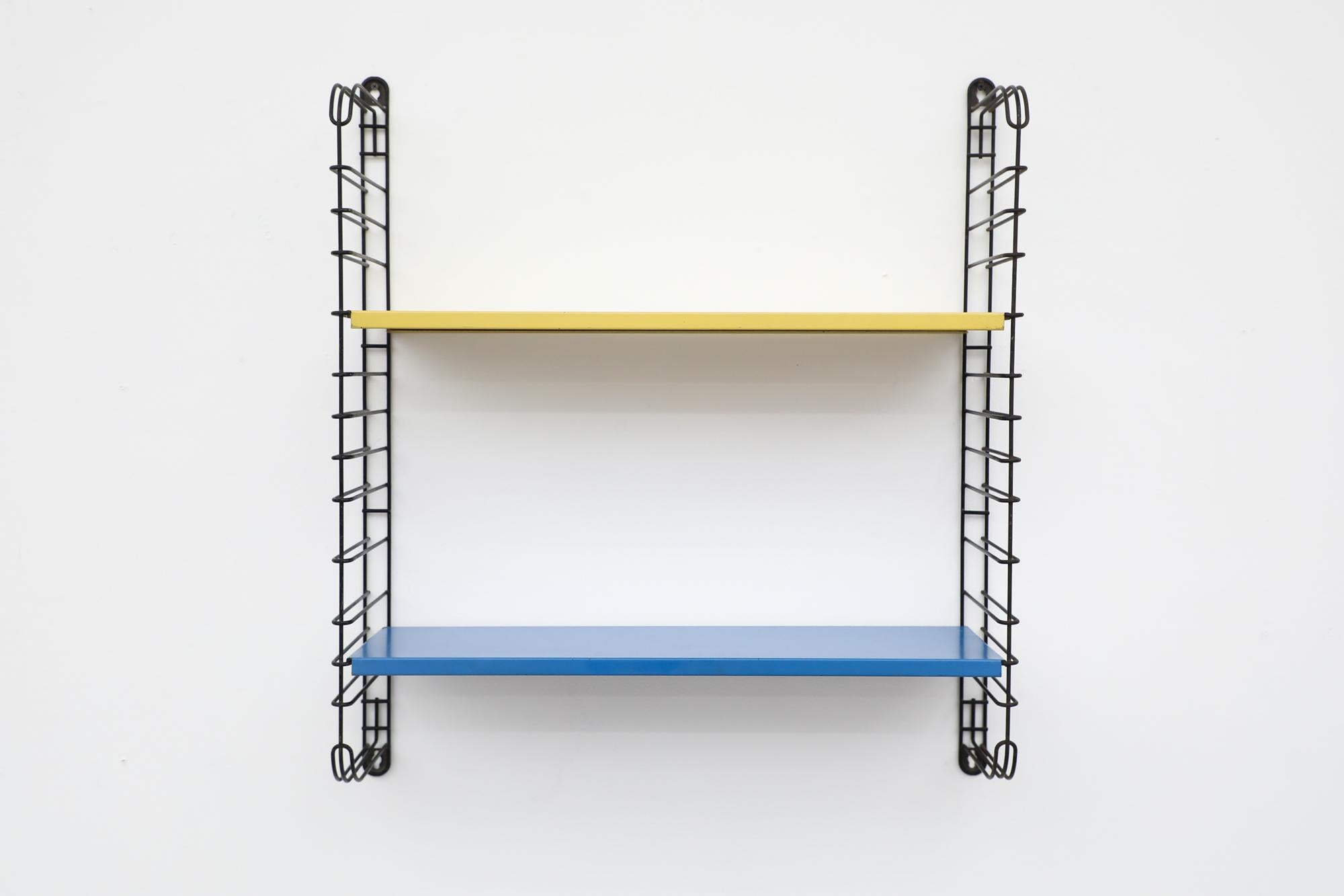Midcentury TOMADO industrial shelving with yellow and blue shelves on black enameled metal wire risers. Designed by Jan van der Togt. The shelves rest on the wire risers and can be arranged to different positions. In original condition with visible
