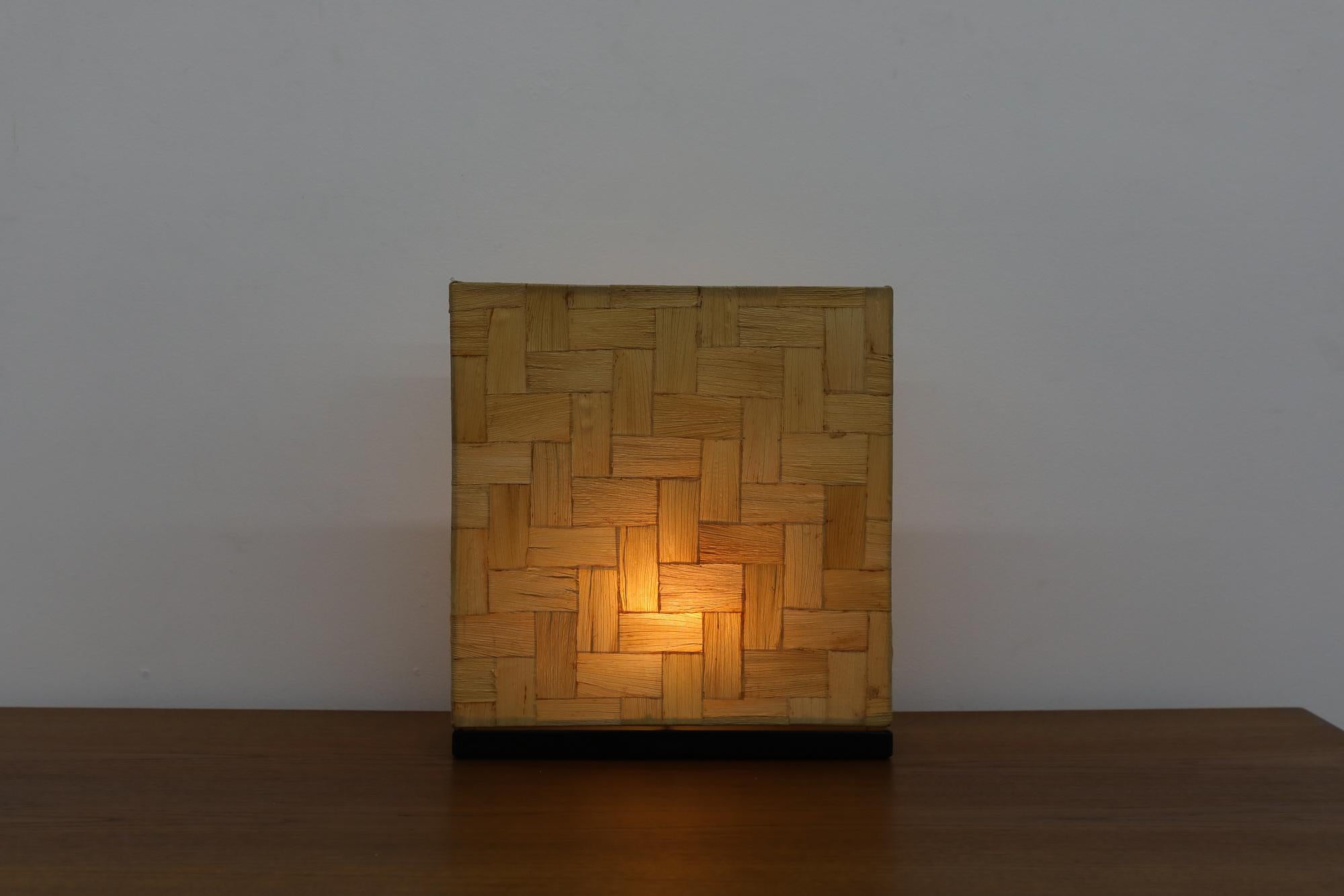 A beautiful Mid-Century table lamp featuring a distinctive rectangle woven bamboo shade, designed with an elegance that draws inspiration from the sophisticated works of Tommaso Barbi.

The lamp's unique shade, crafted from woven bamboo, is