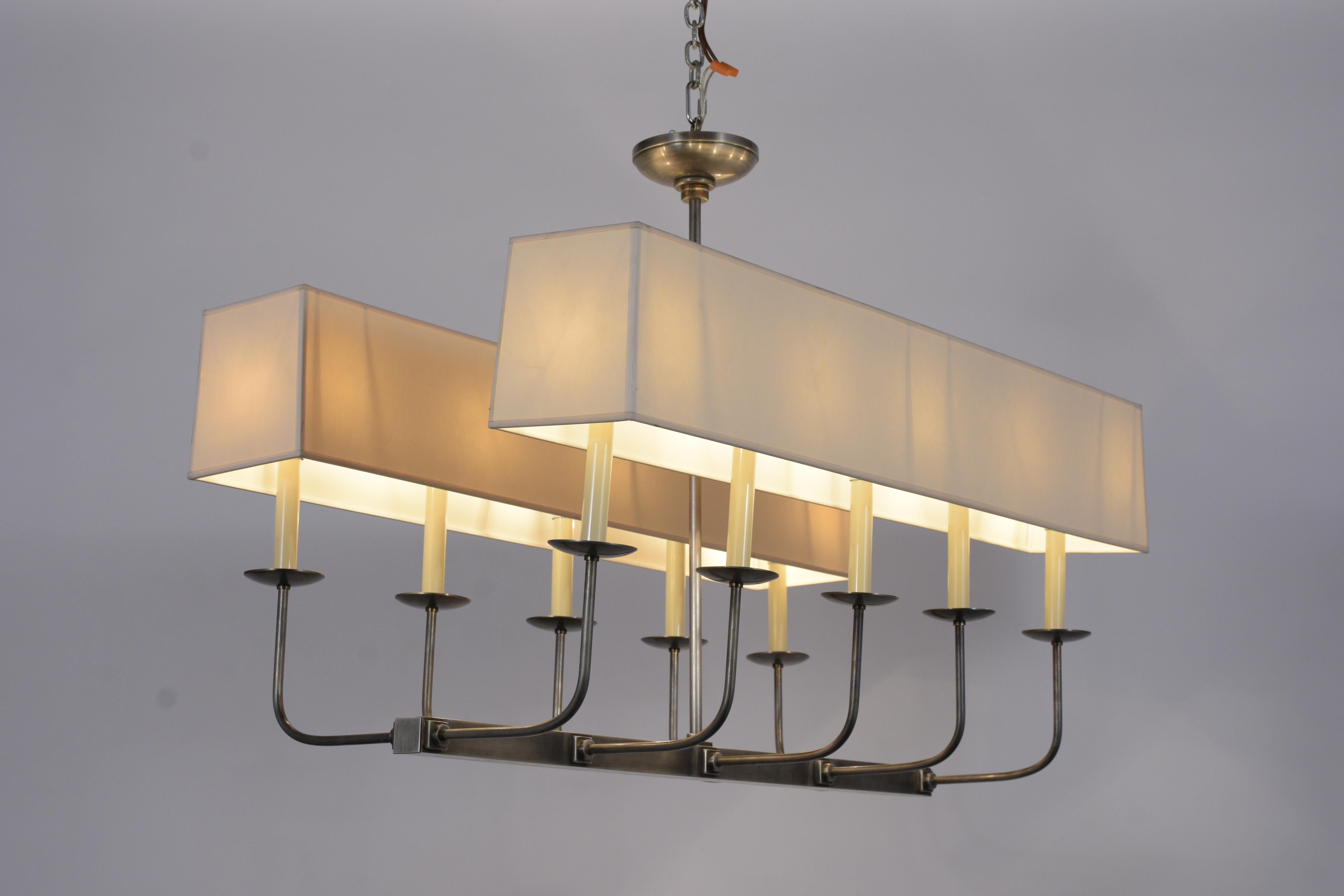 This 1950's Tommi Parzinger 10-arm chandelier is in great condition is made from nickel-plated metal and comes with its original paper light shades in good condition. The Mid-Century Modern Parzinger chandelier is wired to US standards is in working