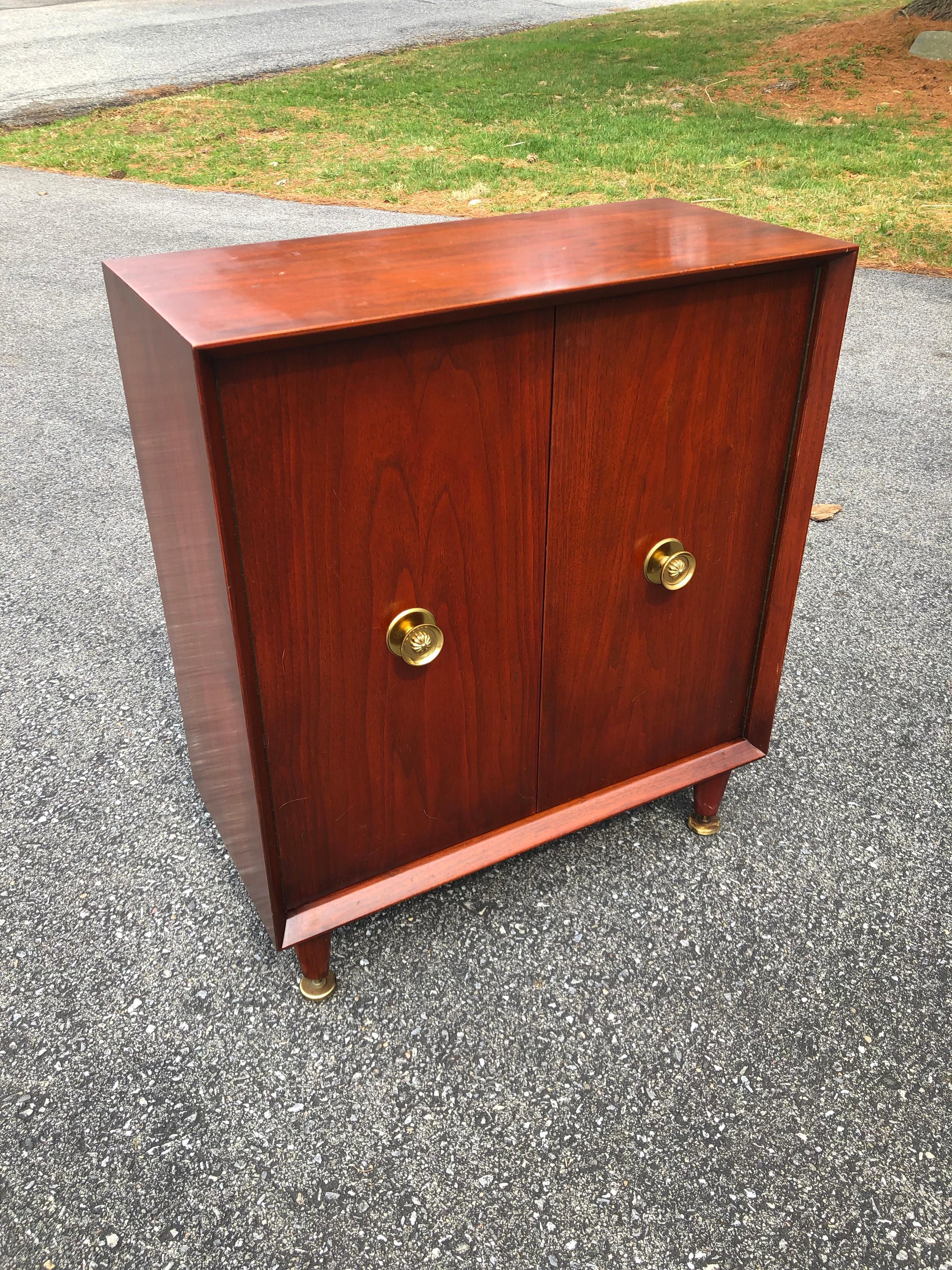 Midcentury Tommi Parzinger diminutive storage cabinet
Ribbon grain mahogany with wonderful color, two doors. Sculptural brass handles and feet.