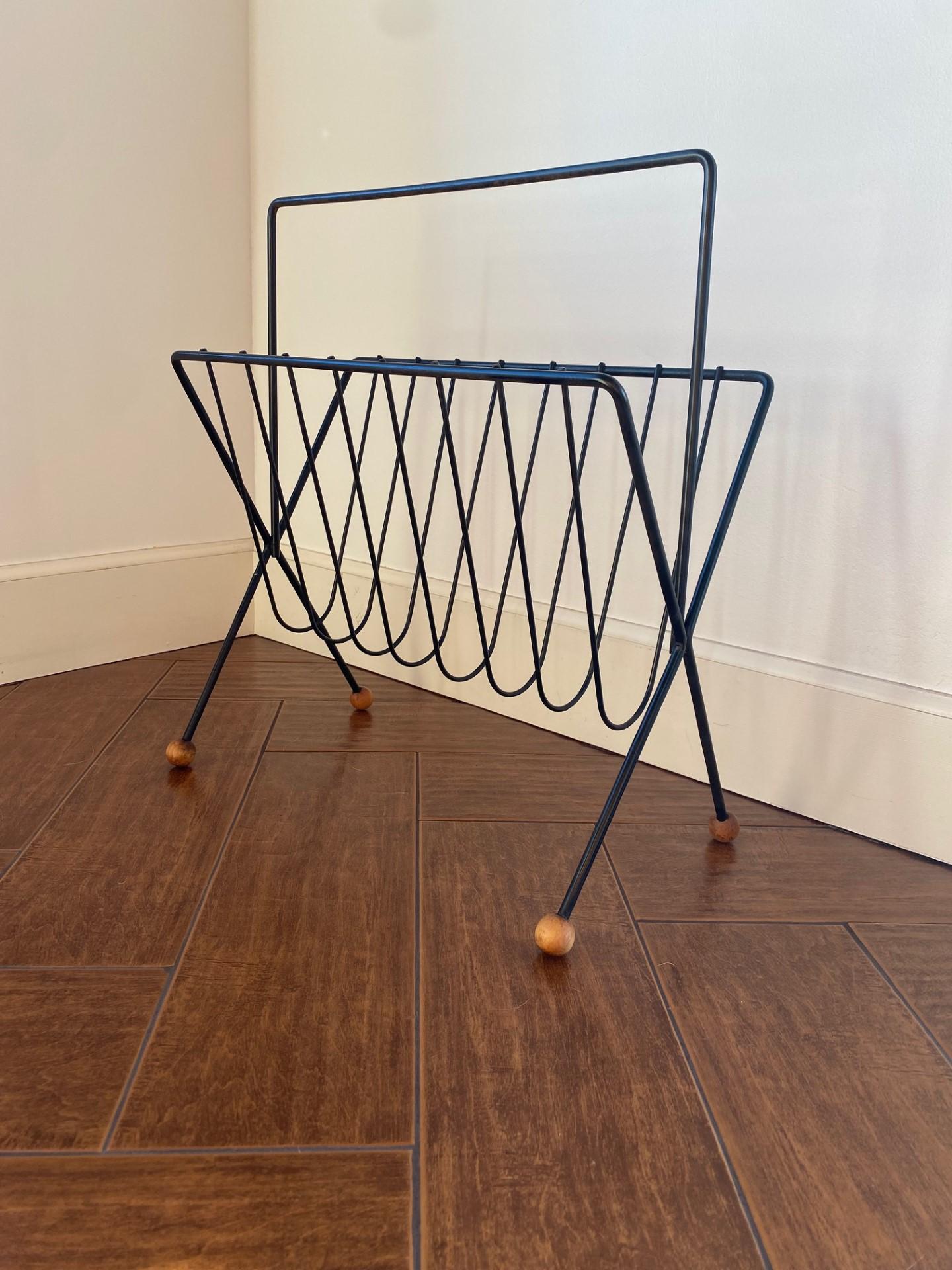 Incredibly stylish Tony Paul wrought iron and wood magazine rack for Woodlin-Hall.  Beautifully crafted as a skeletal iron frame with ball feet (wood) , this rack demands stylish attention.  In great original finish, this piece evokes pure