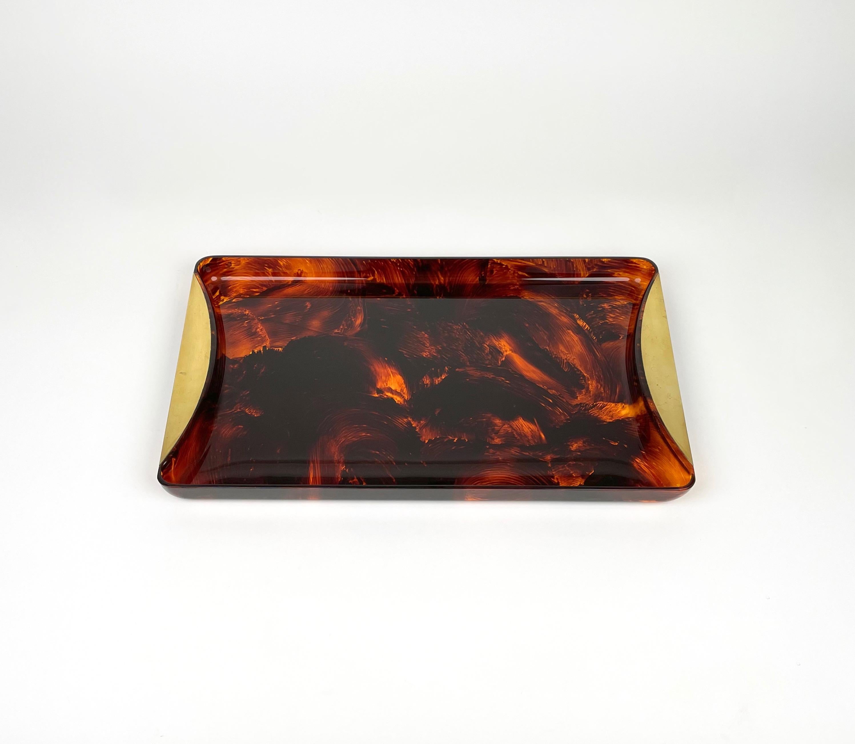 Rectangular serving tray in tortoiseshell-effect lucite with brass handles designed by Guzzini. Made in Italy in the 1970s. 

The original label 