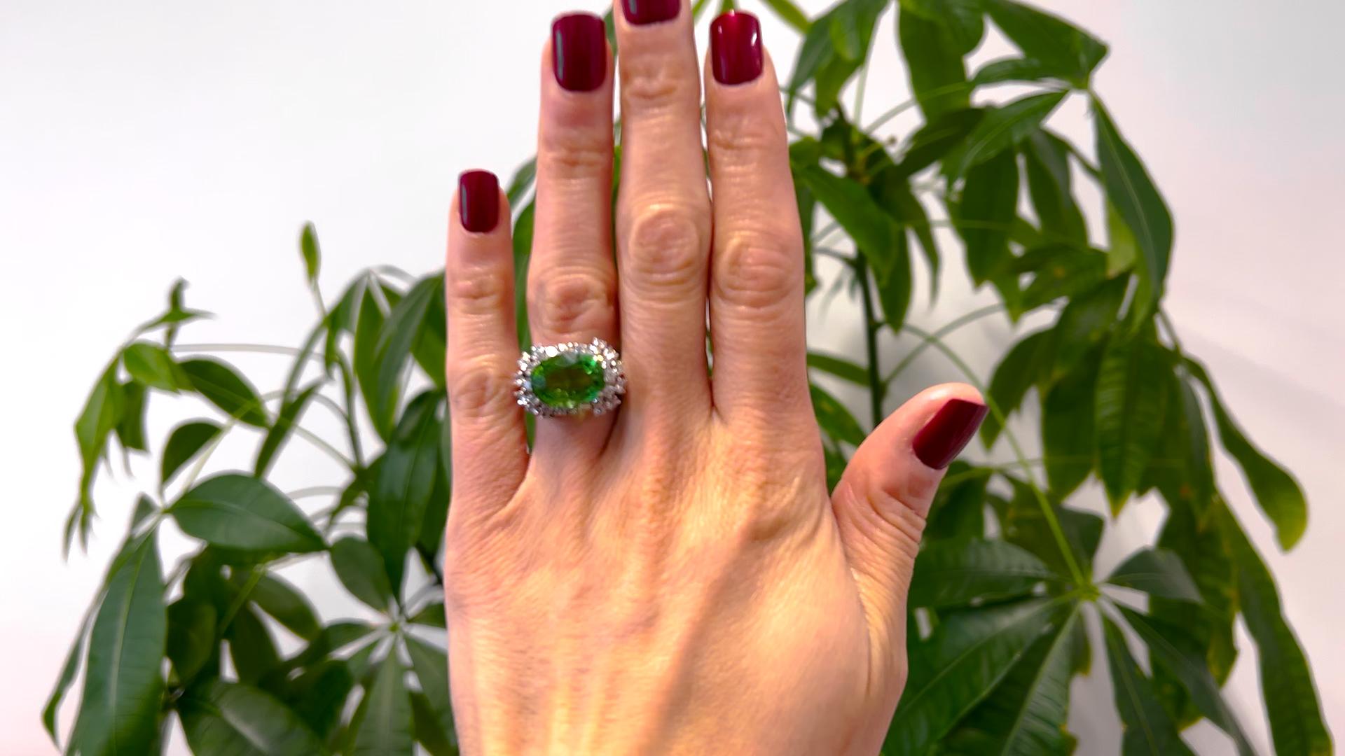 One Mid Century Tourmaline Diamond 18k White Gold Cocktail Ring. Featuring one oval mixed cut green tourmaline weighing approximately 6.70 carats. Accented by 28 transitional cut diamonds with a total weight of approximately 1.45 carats, graded F-G