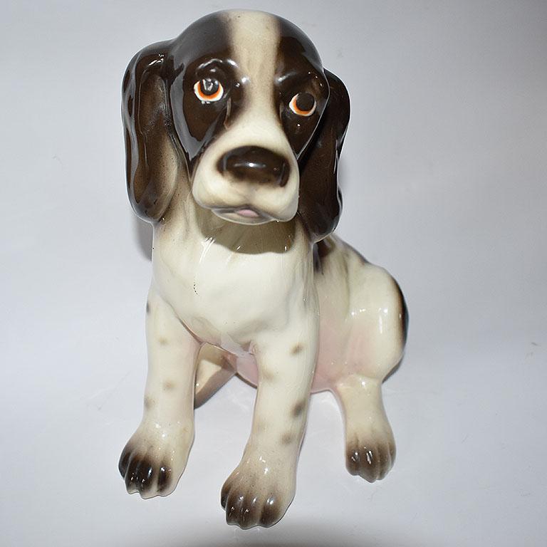 A superb tall midcentury brown and white Spaniel ceramic dog figurine. This charming pup has a brown and white coat, with a pale pink underbelly, and a small tail which peeks out from behind. He (or she) is hand painted in fine detail and would be a