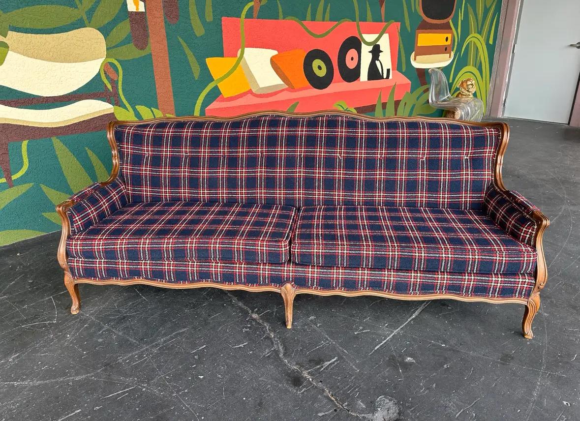 Mid Century Traditional style navy window pane wool plaid sofa with wood trim, made by Gimble Brothers c.1960’s. Lovely wingback shape with scalloped wood trim and carved feet and arms. 
Upholstery is a rich navy blue wool textured fabric with white