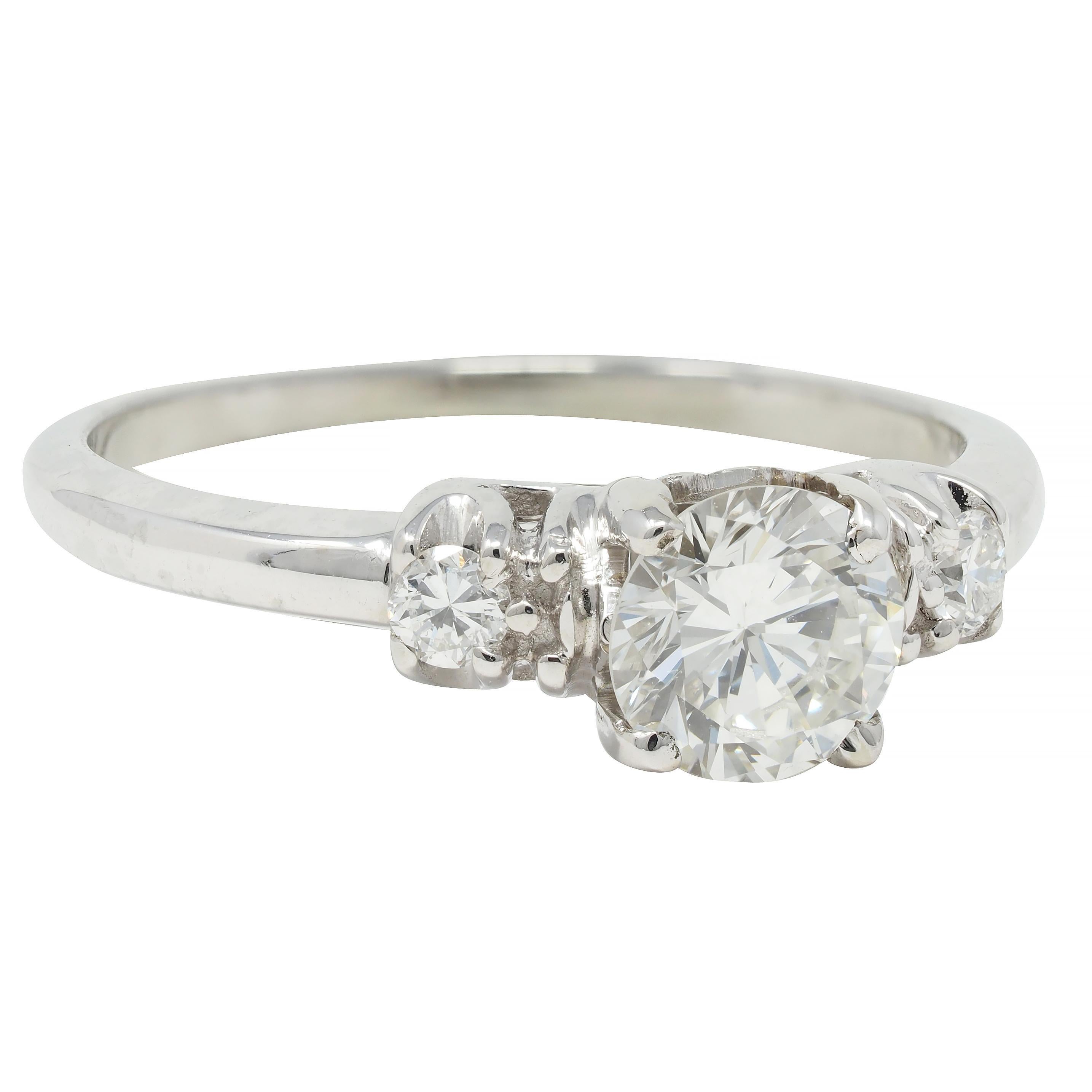 Centering a transitional cut diamond weighing approximately 0.59 carat total - G color with VS2 clarity
Prong set in a pierced arch motif basket and flanked by additional transitional cut diamonds 
Weighing approximately 0.06 carat total - eye clean