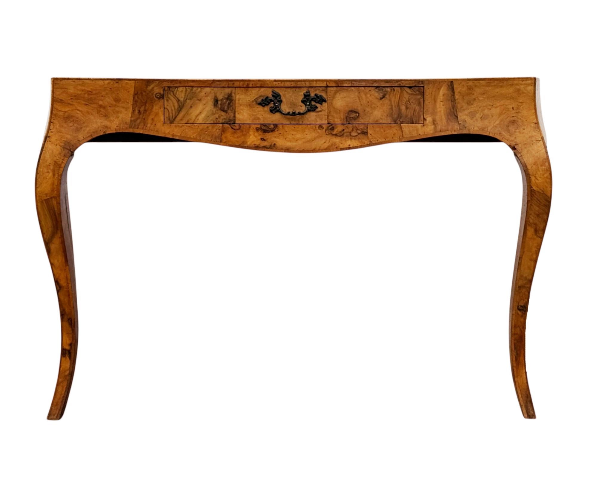 Un impresionante escritorio italiano de madera burl, muy estilizado. Presenta un bello acabado de madera burlada con un cajón grande para guardar cosas. Genial  profundidad para espacios estrechos. Marcado Italia. 