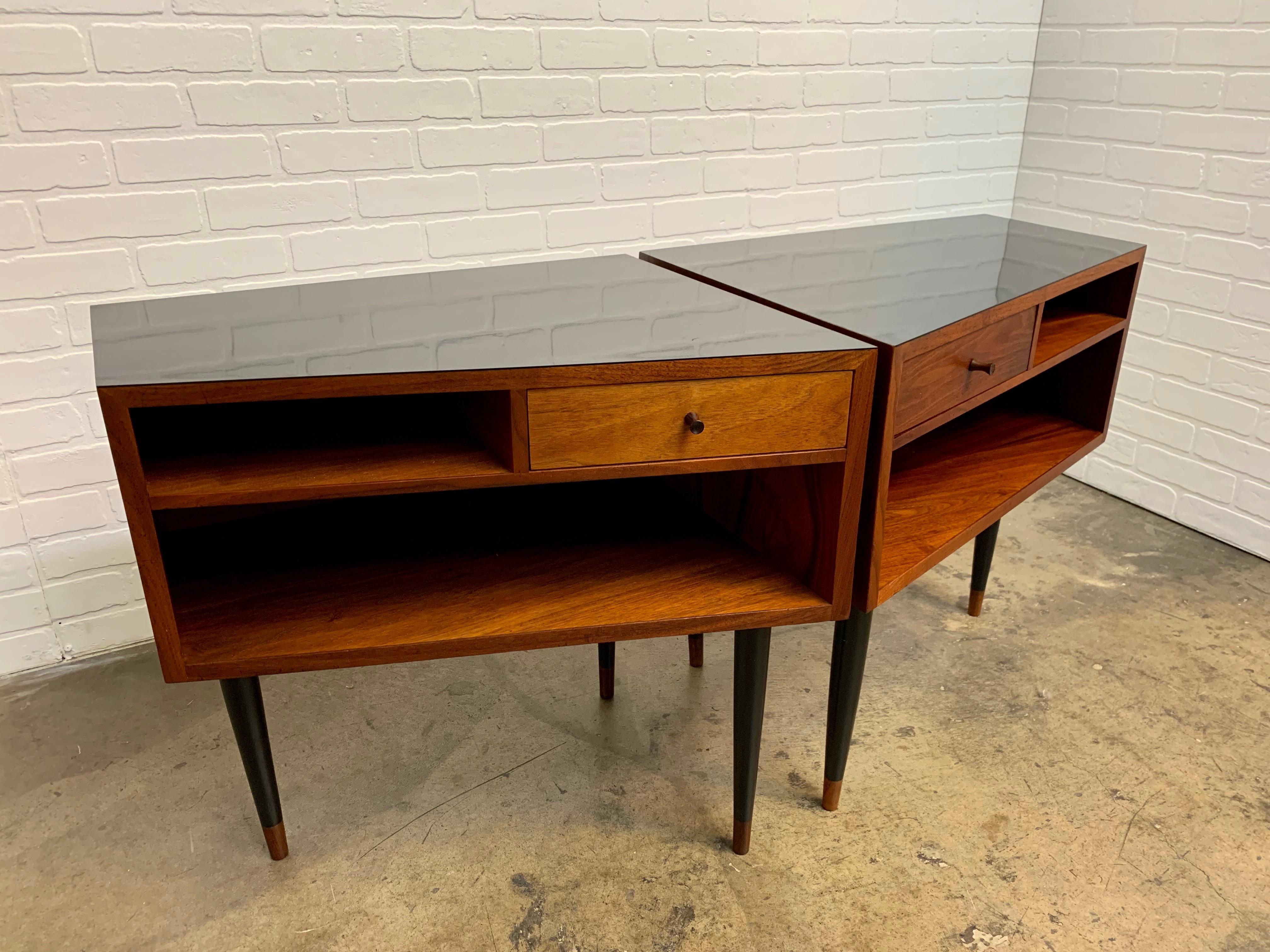 Walnut with black laminate top nightstands with ebonized legs in a trapezoid shape. Made by Glenn of California but the label is missing from the inside of the drawer (please see pictures ) original legs were replaced with vintage midcentury era