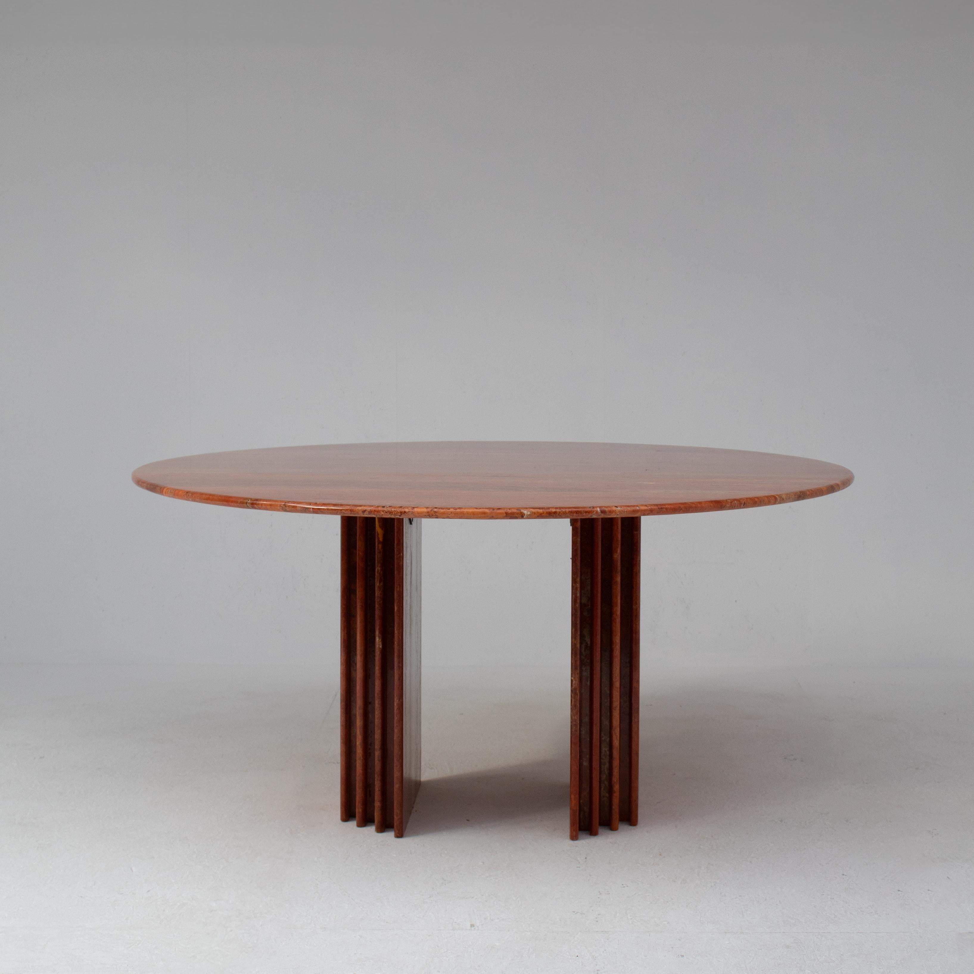 This Travertine Dining Table from the 1970s shows the essence of Italian mid-century design. The round Rosso Travertino top displays warm red tones and unique veins that shift with the light. Each glance reveals new details and makes the stone feel