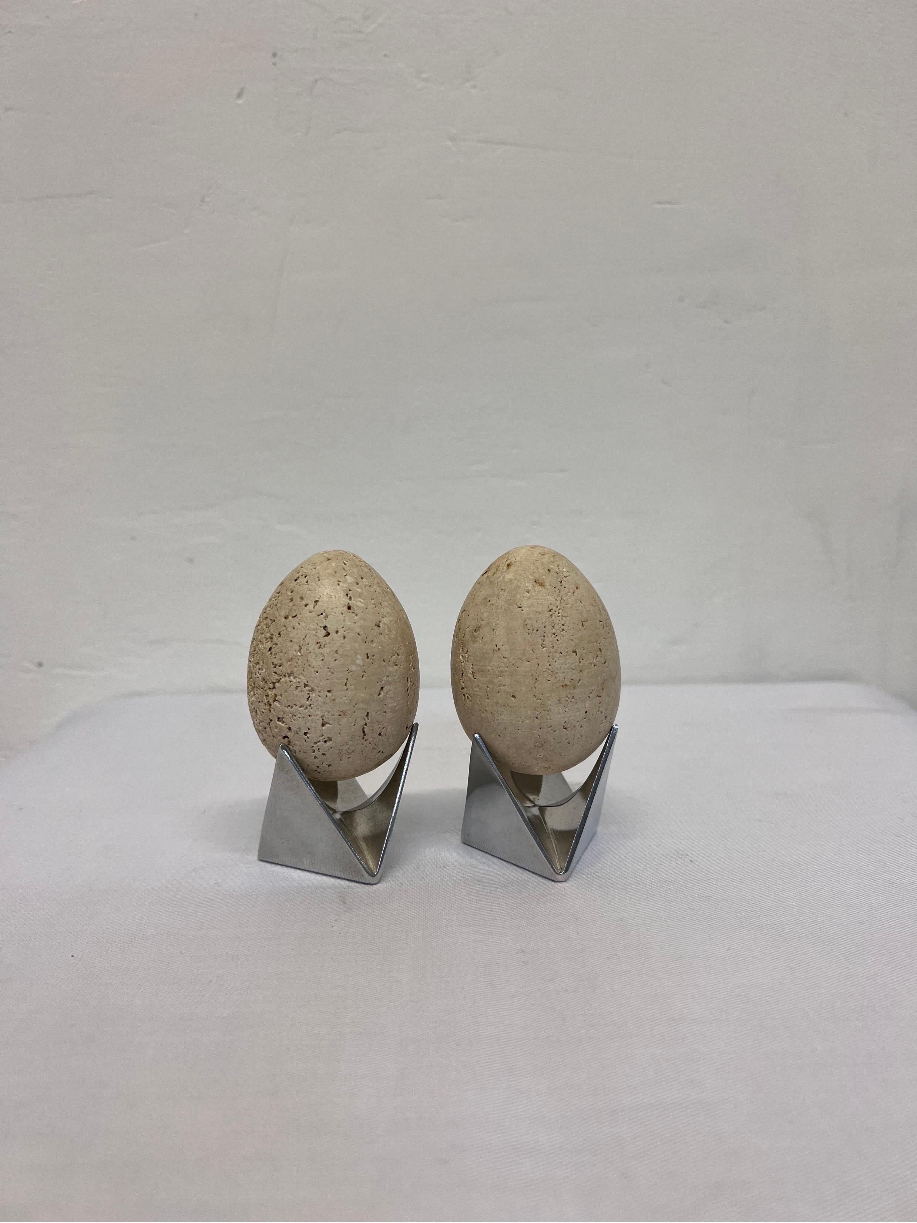 Pair of mid-century travertine eggs from an unknown sculptor supported by a pair of Alessi Roost Egg holders by Adam Goodrum.